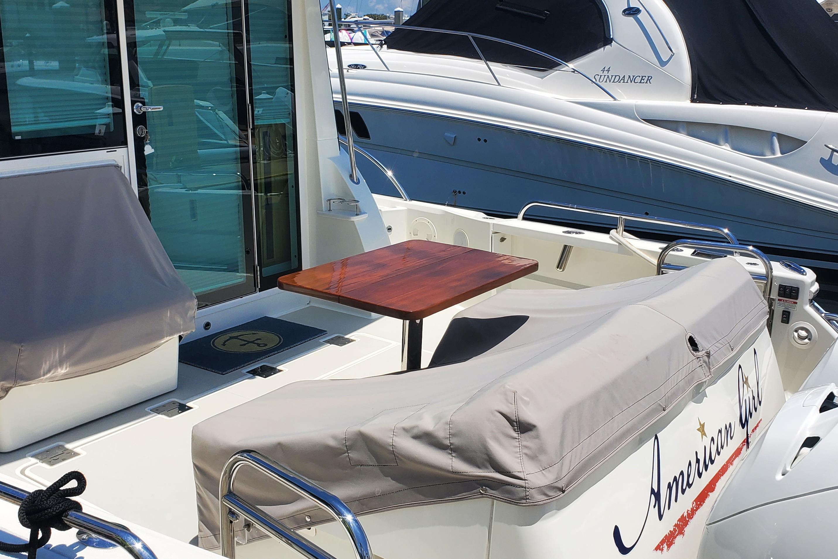 2021 Back Cove 390 yacht with covered seating and wooden table on deck.