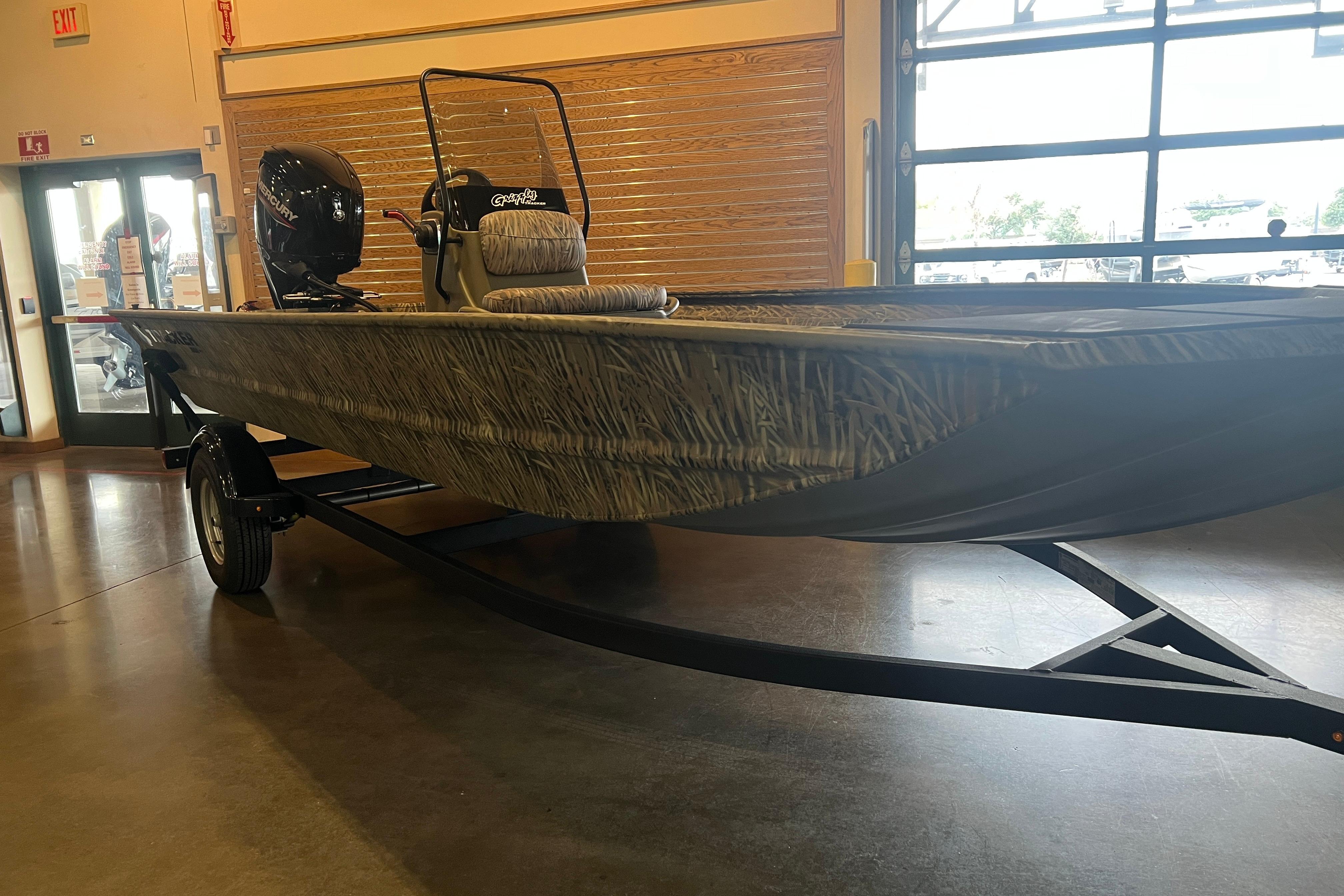 2026 Tracker Grizzly 1860 CC boat displayed indoors on a trailer.
