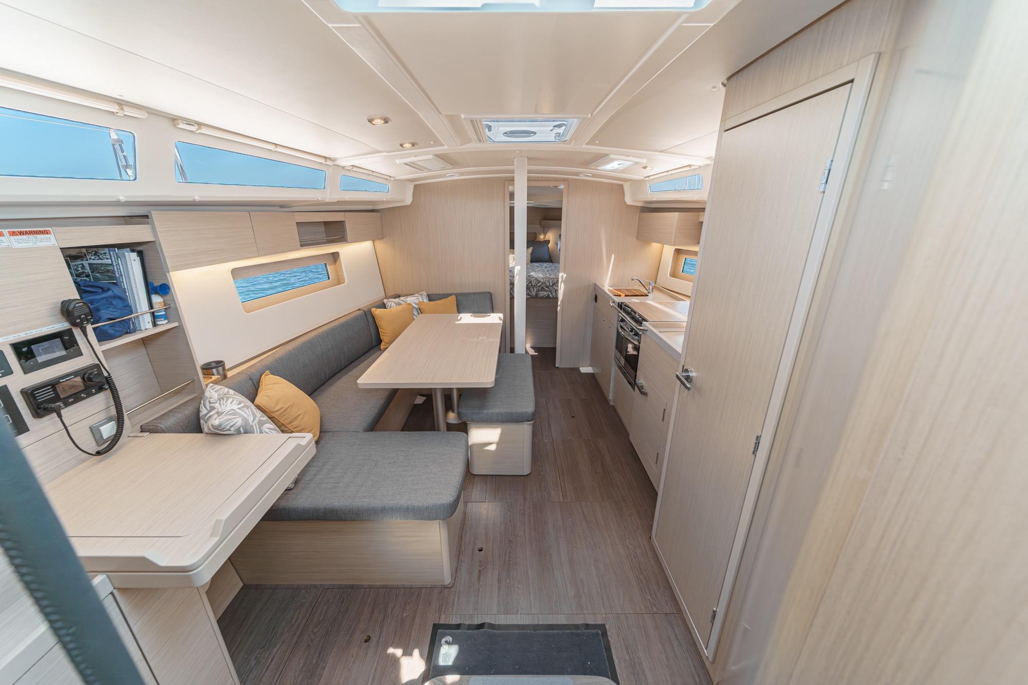 Interior of 2025 Beneteau Oceanis 37.1 yacht, featuring modern seating and kitchen area.