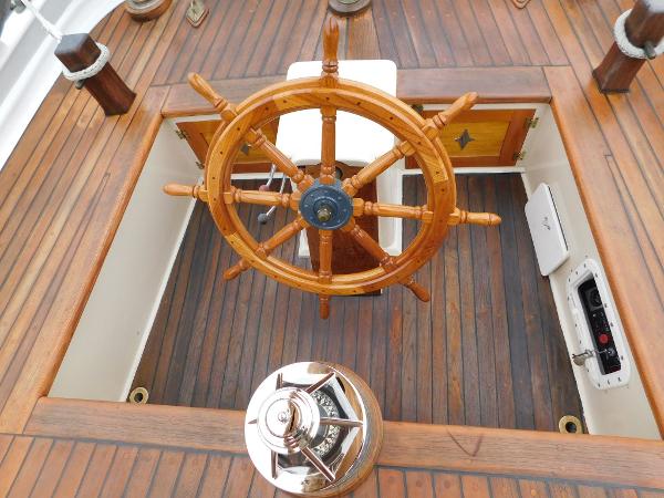 Wooden helm of 1983 Custom Murray Peterson Coaster III sailboat, featuring classic nautical design.