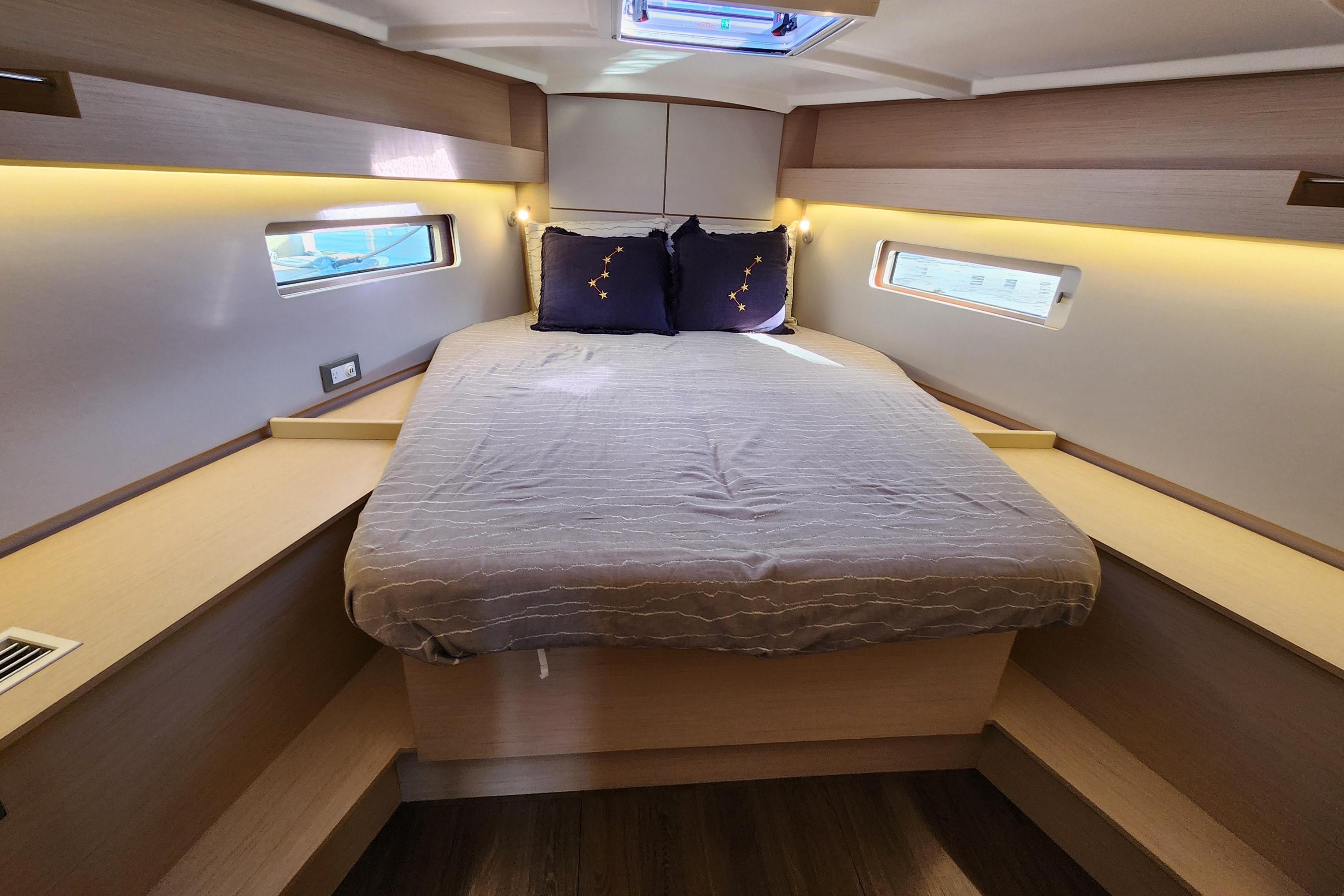 Cozy cabin interior of 2022 Beneteau Oceanis 40.1 yacht with modern design and ambient lighting.