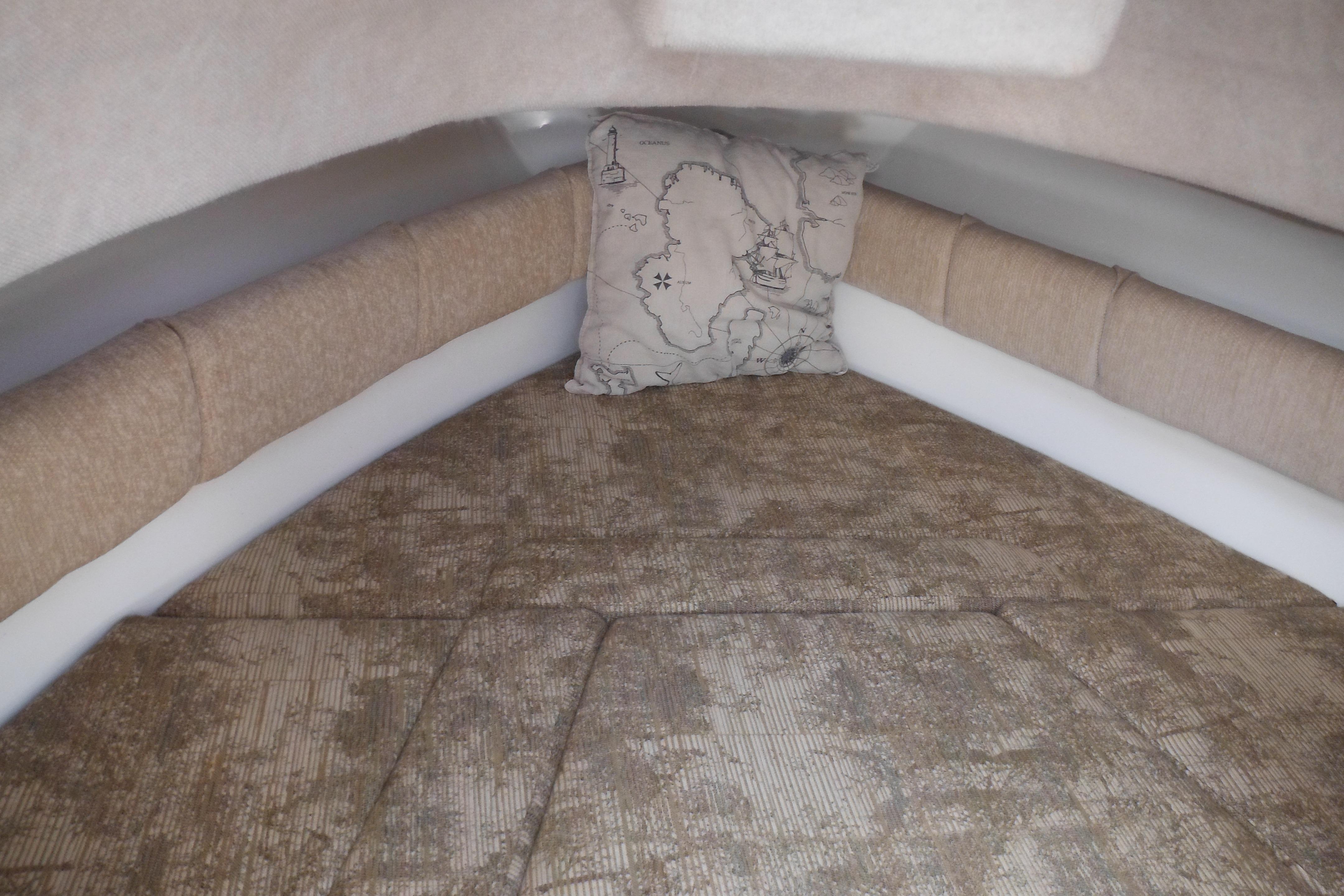 2005 Seaswirl Striper 2101 Walkaround O/B cabin interior with cushioned seating and decorative pillow.
