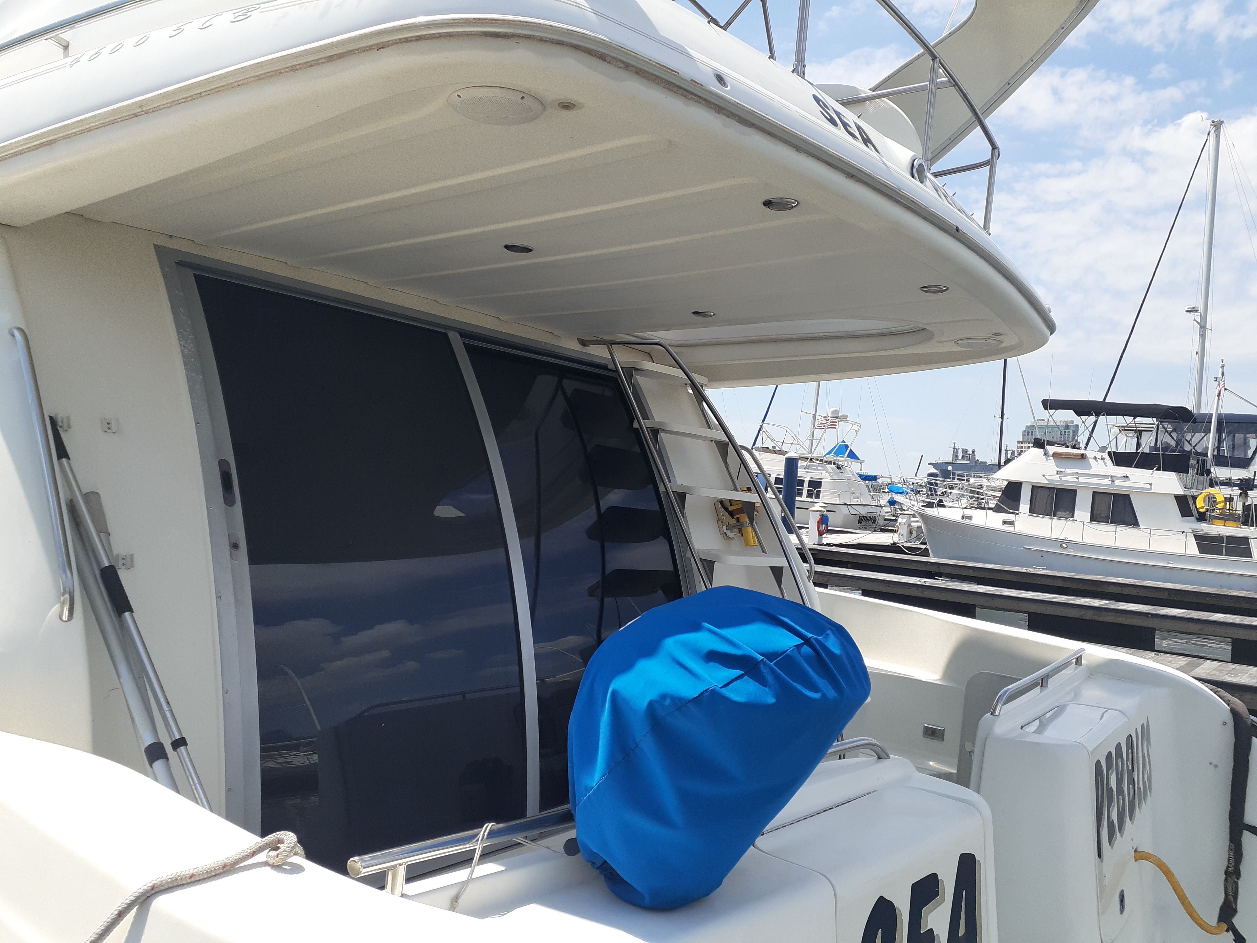 A 2000 Maxum 4600 SCB docked at a marina. It features a spacious deck and a ladder.