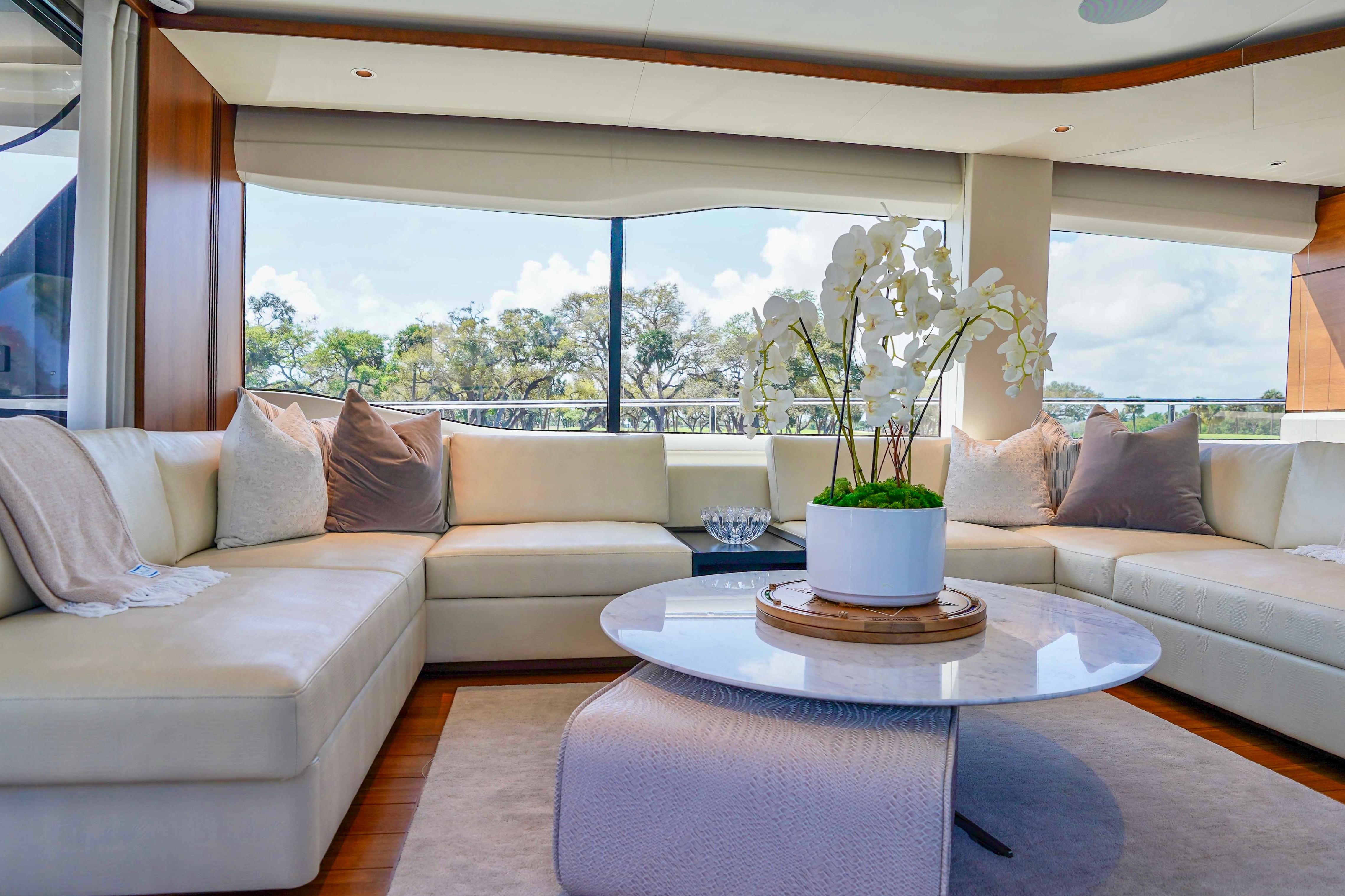 Luxurious 2021 Princess Y85 yacht interior with elegant seating and decorative orchid centerpiece.