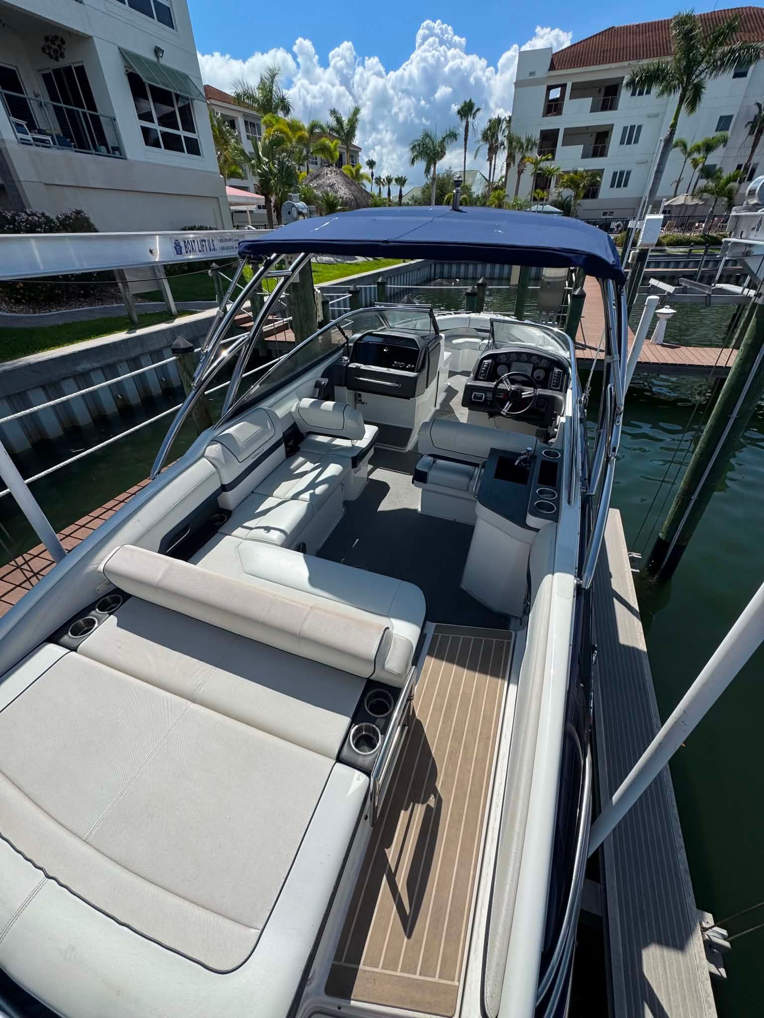2018 Formula 270 Bowrider boat docked with blue canopy.