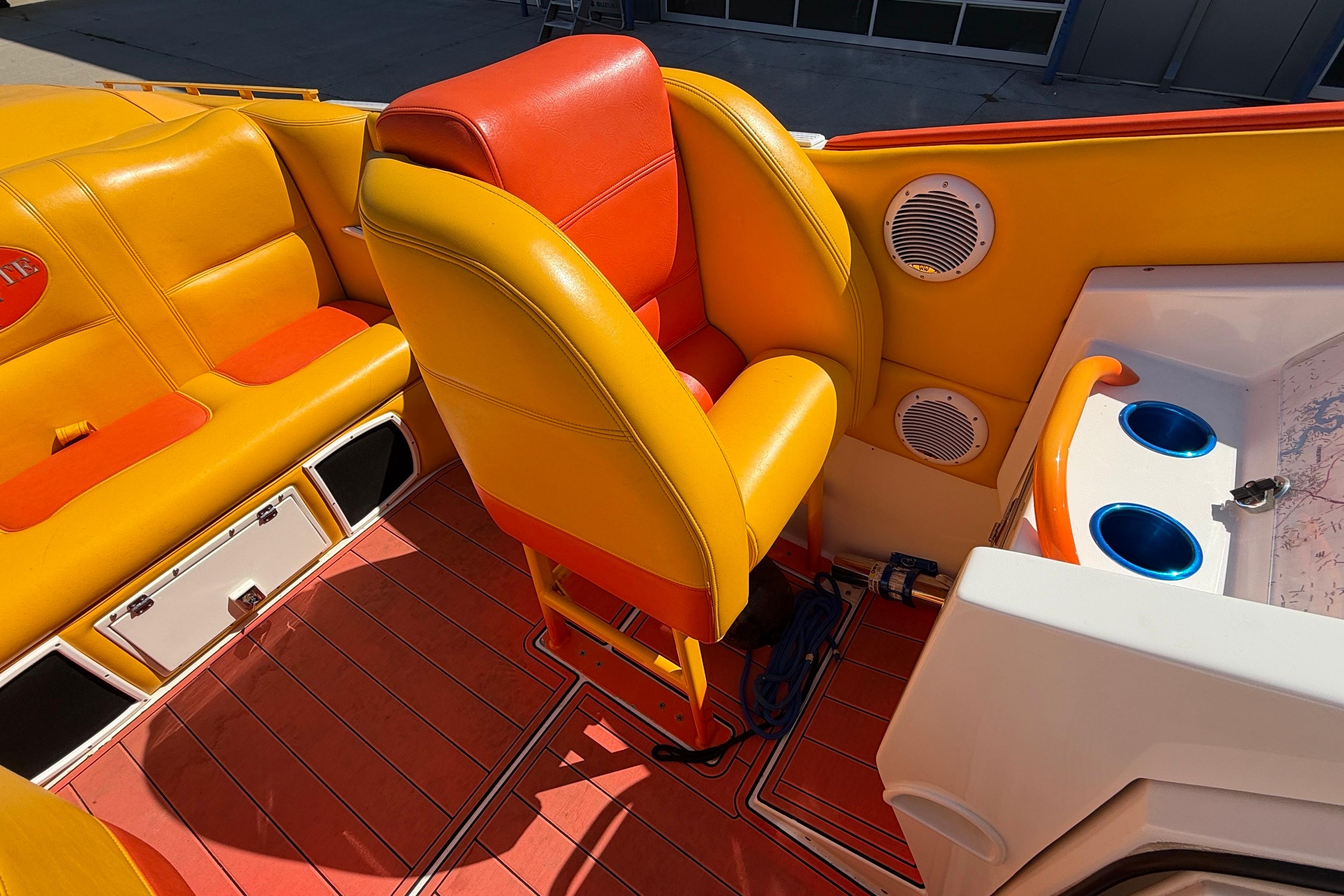 Interior of a 2002 Cigarette 35' Cafe Racer boat with vibrant orange and yellow seating.