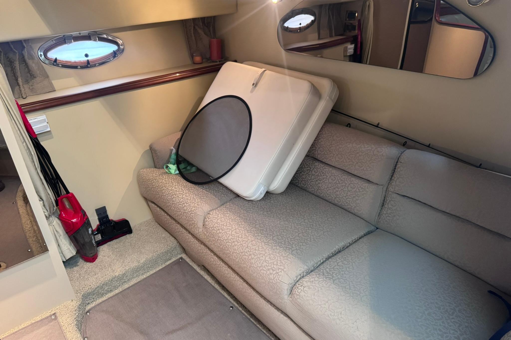 Interior of 2002 Cruisers Yachts 3275 Express with sofa and porthole window.
