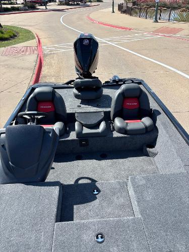 2025 Tracker Savage 215 boat with dual seats and outboard motor, parked on a paved area.