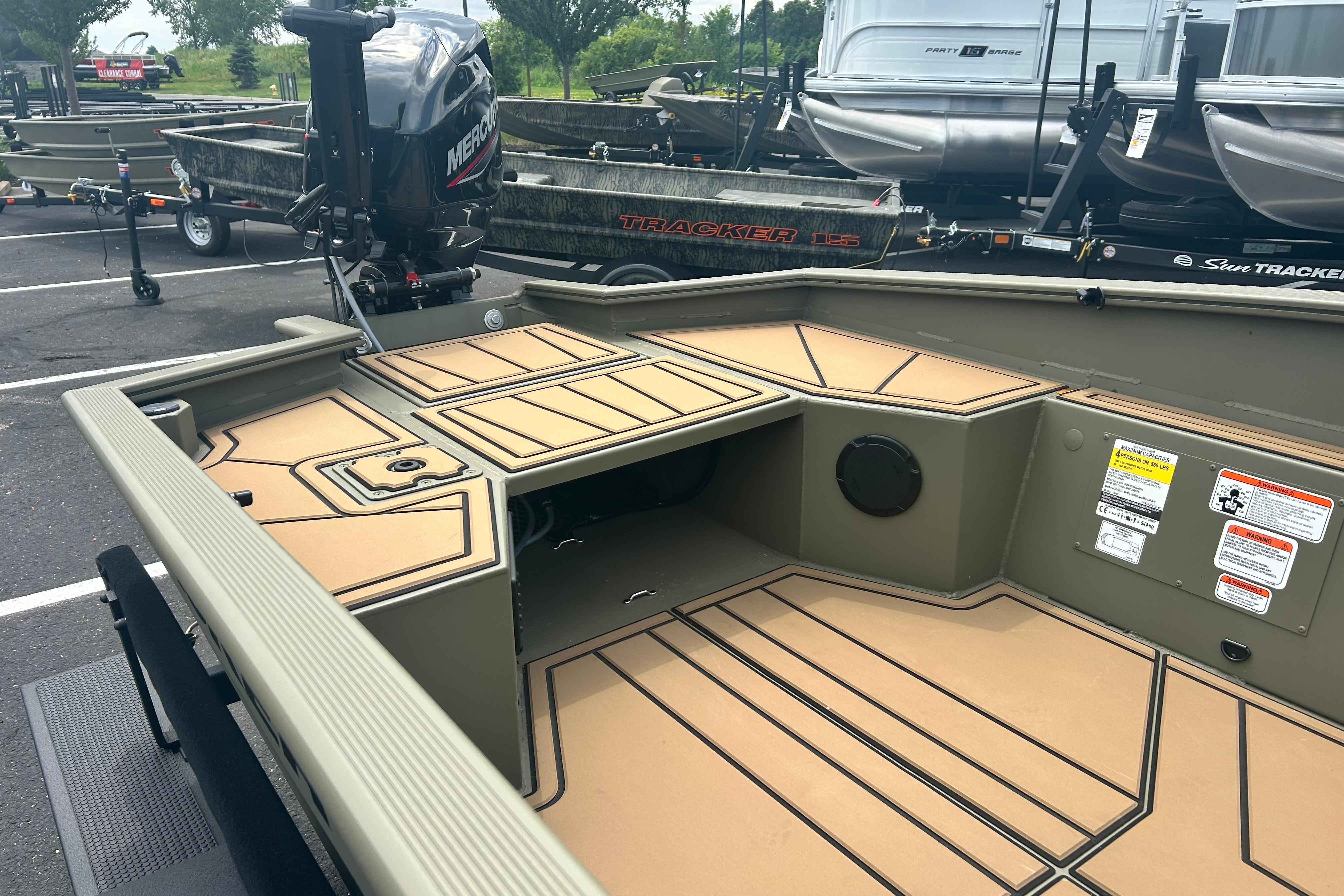 2026 Tracker Grizzly 1650 T Prairie Wings Edition boat interior with Mercury engine in parking lot.