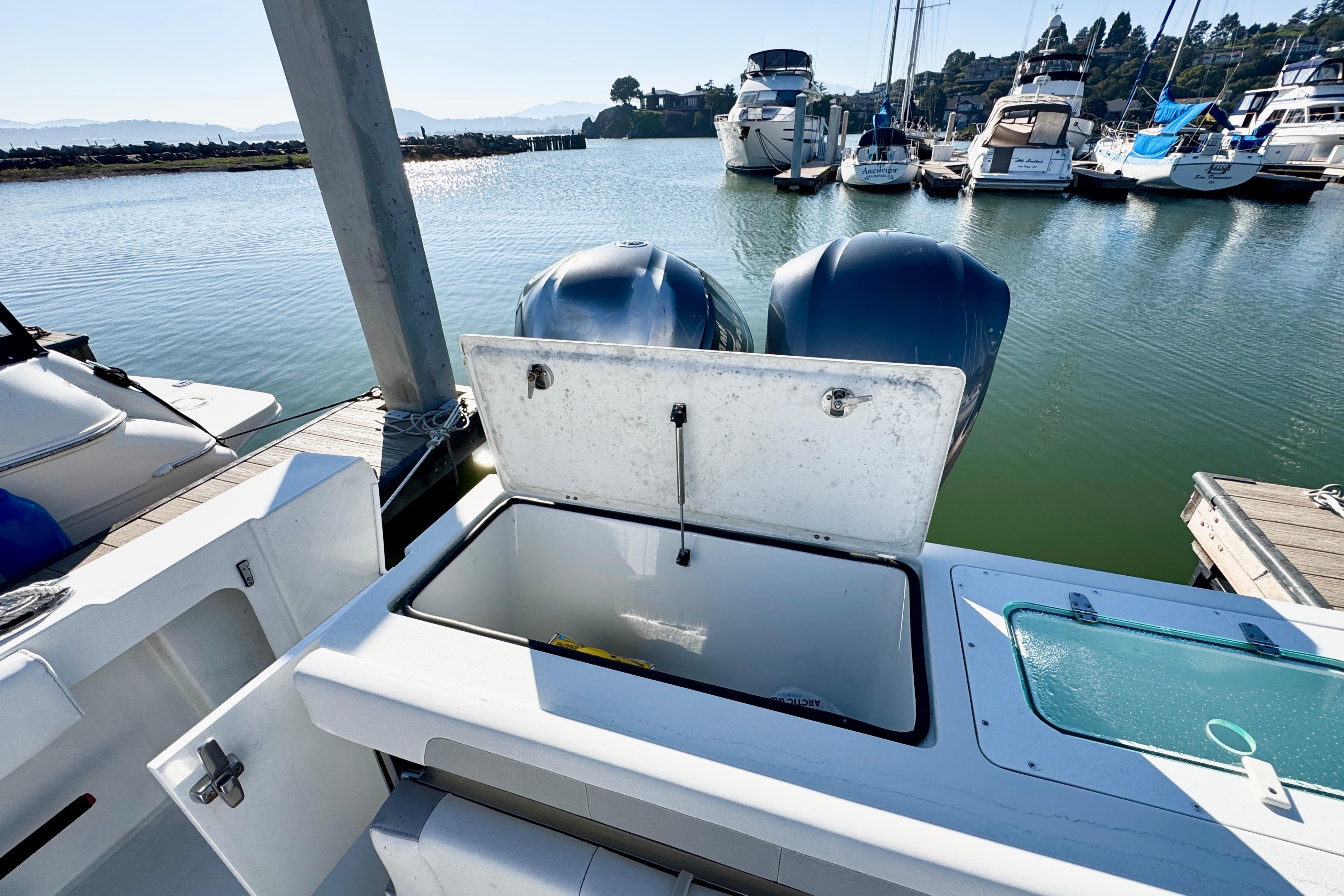 2021 Parker 2820 XLD Sport Cabin at marina, featuring open storage compartment and twin engines.
