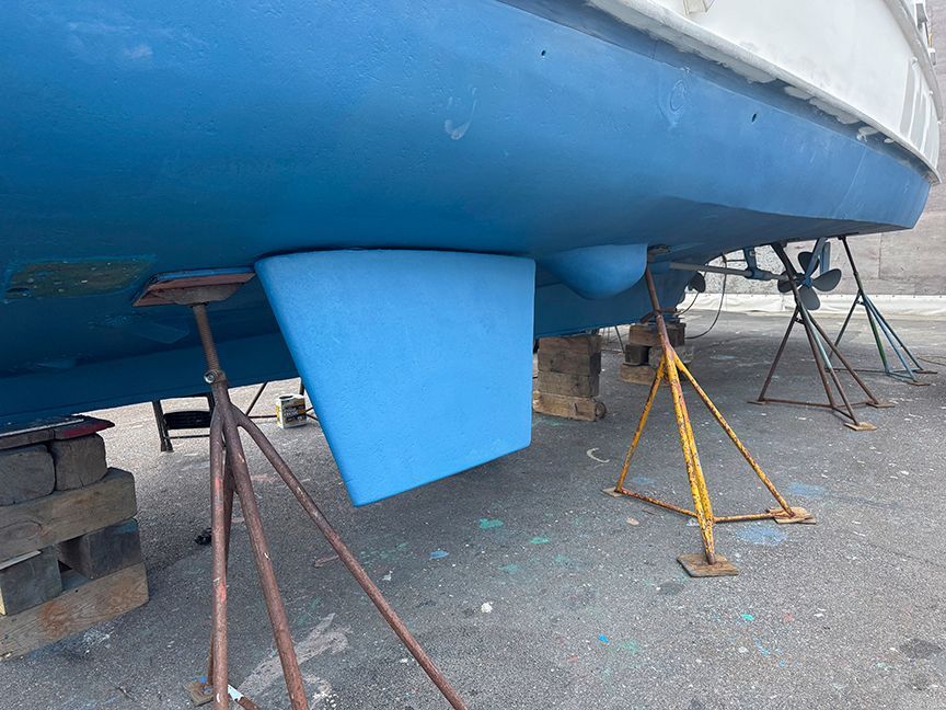 A 1961 Burger 63 boat is propped up, featuring a blue hull and visible propeller.