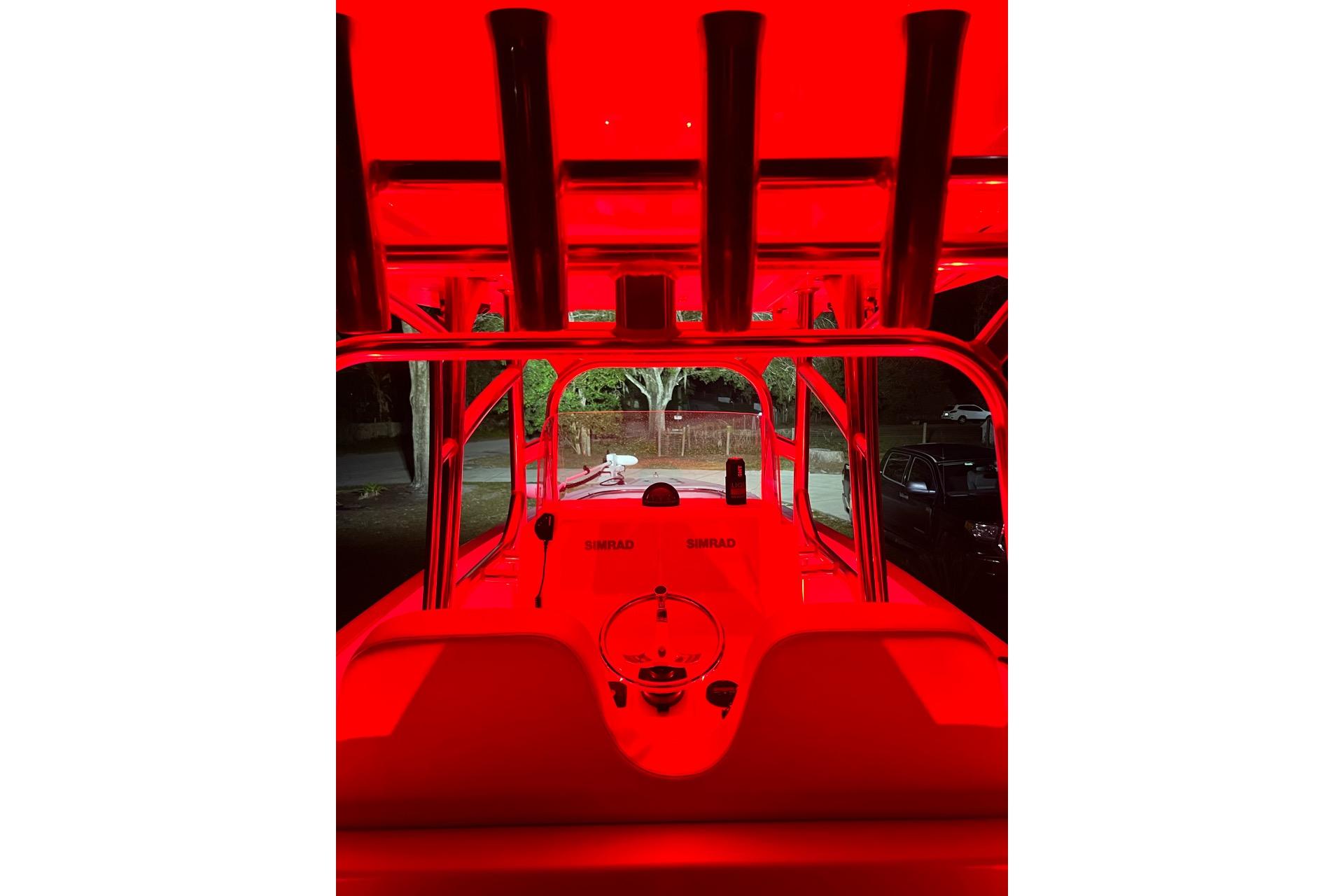 Red-lit interior of a 2021 Custom Infusion 34 CC boat at night.