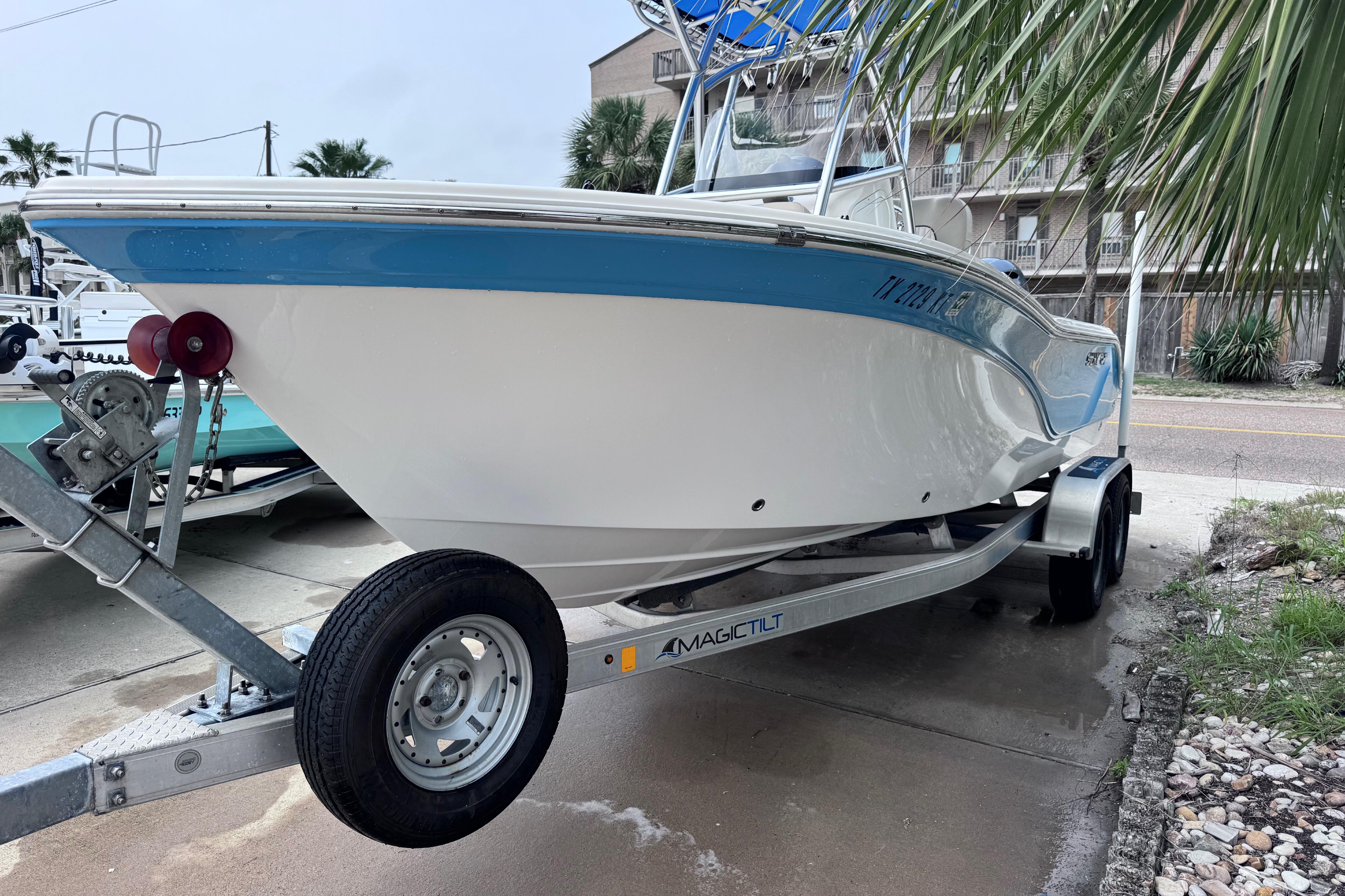 2018 Sea Fox 206 Commander boat on trailer, parked near palm trees.