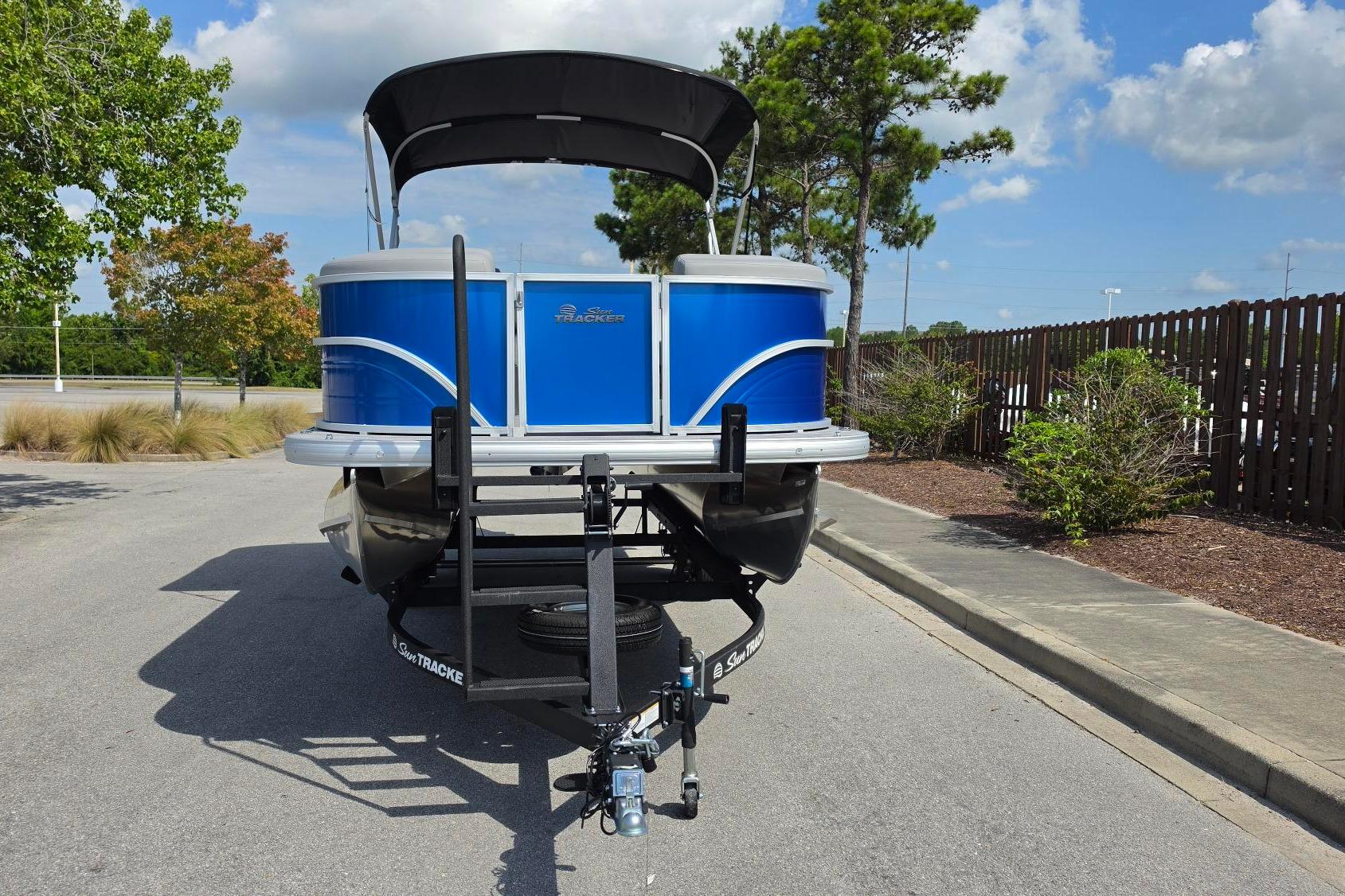 2026 Sun Tracker Party Barge 20 DLX pontoon boat on trailer, parked outdoors.