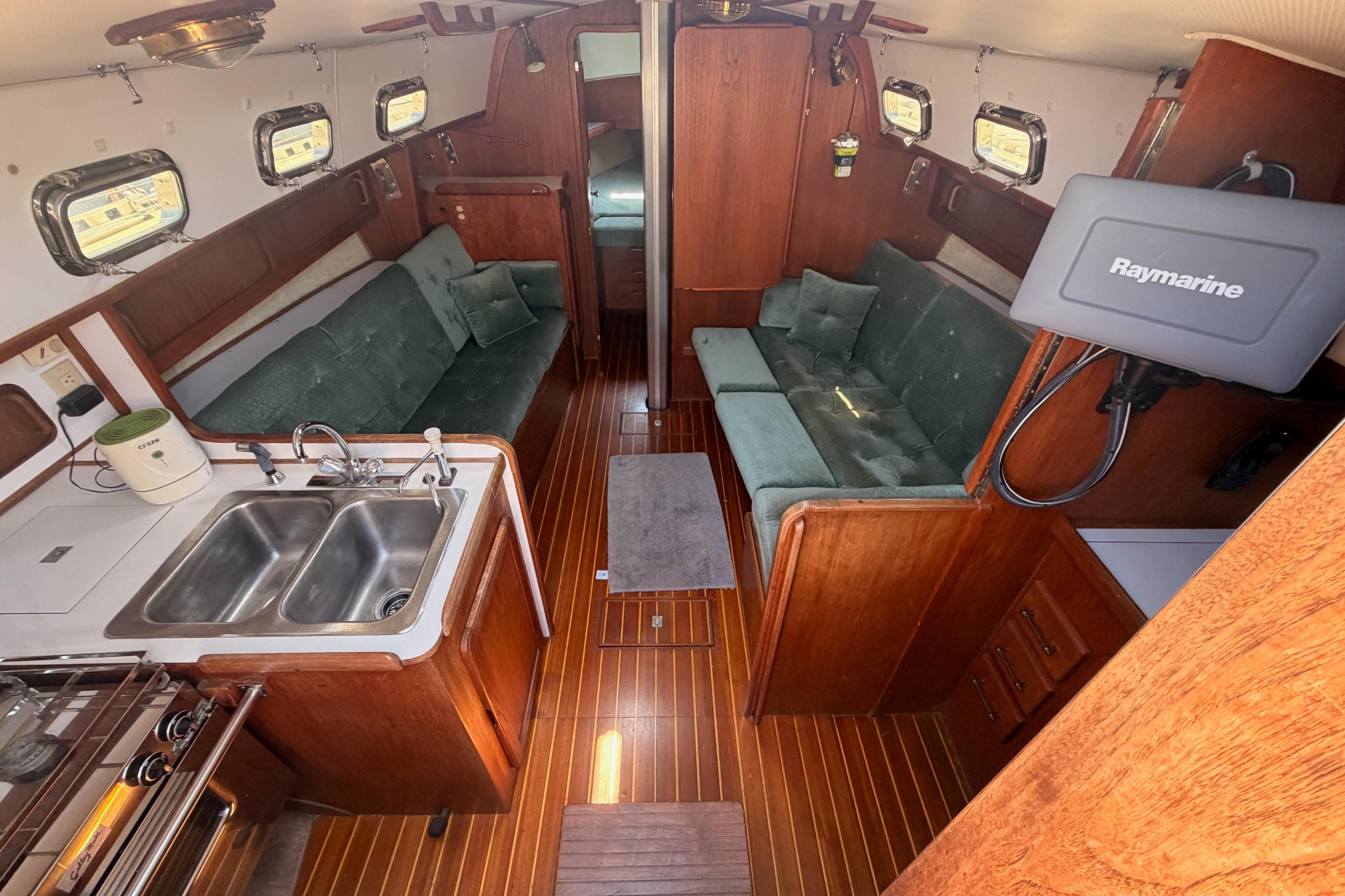 Interior of a 1991 Caliber 33 sailboat with wood finish and green seating.
