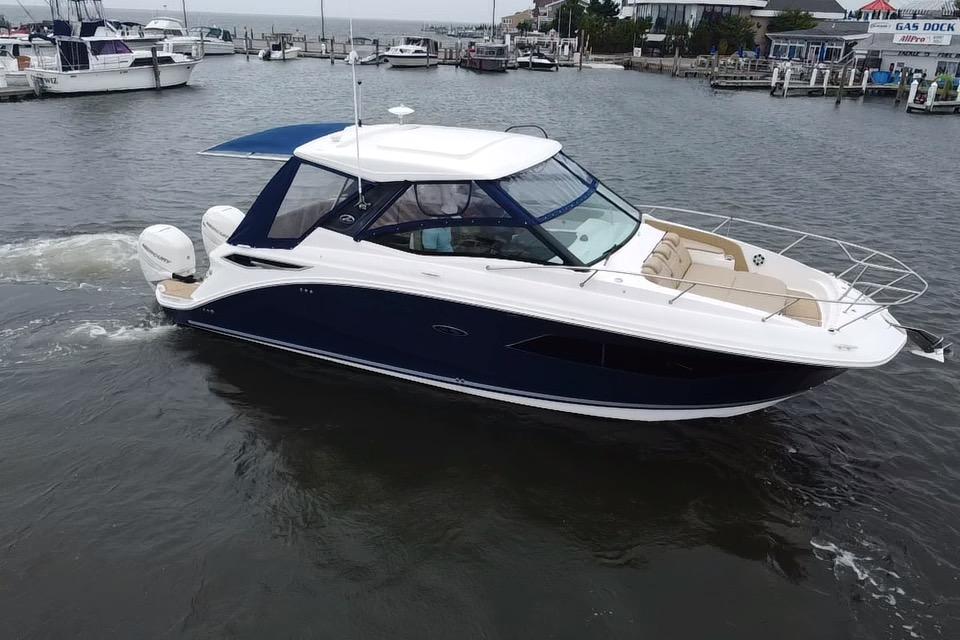 2021 Sea Ray Sundancer 320 Outboard cruising in a marina, showcasing sleek design and luxury features.