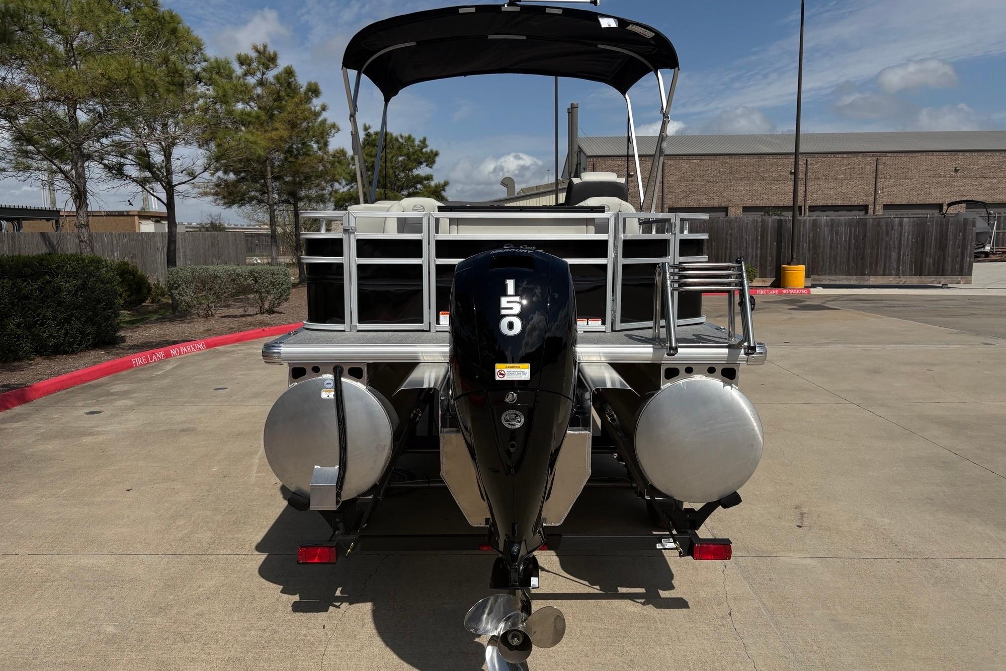2026 Sun Tracker Fishin' Barge 22 XP3 pontoon boat with 150 HP engine, rear view.