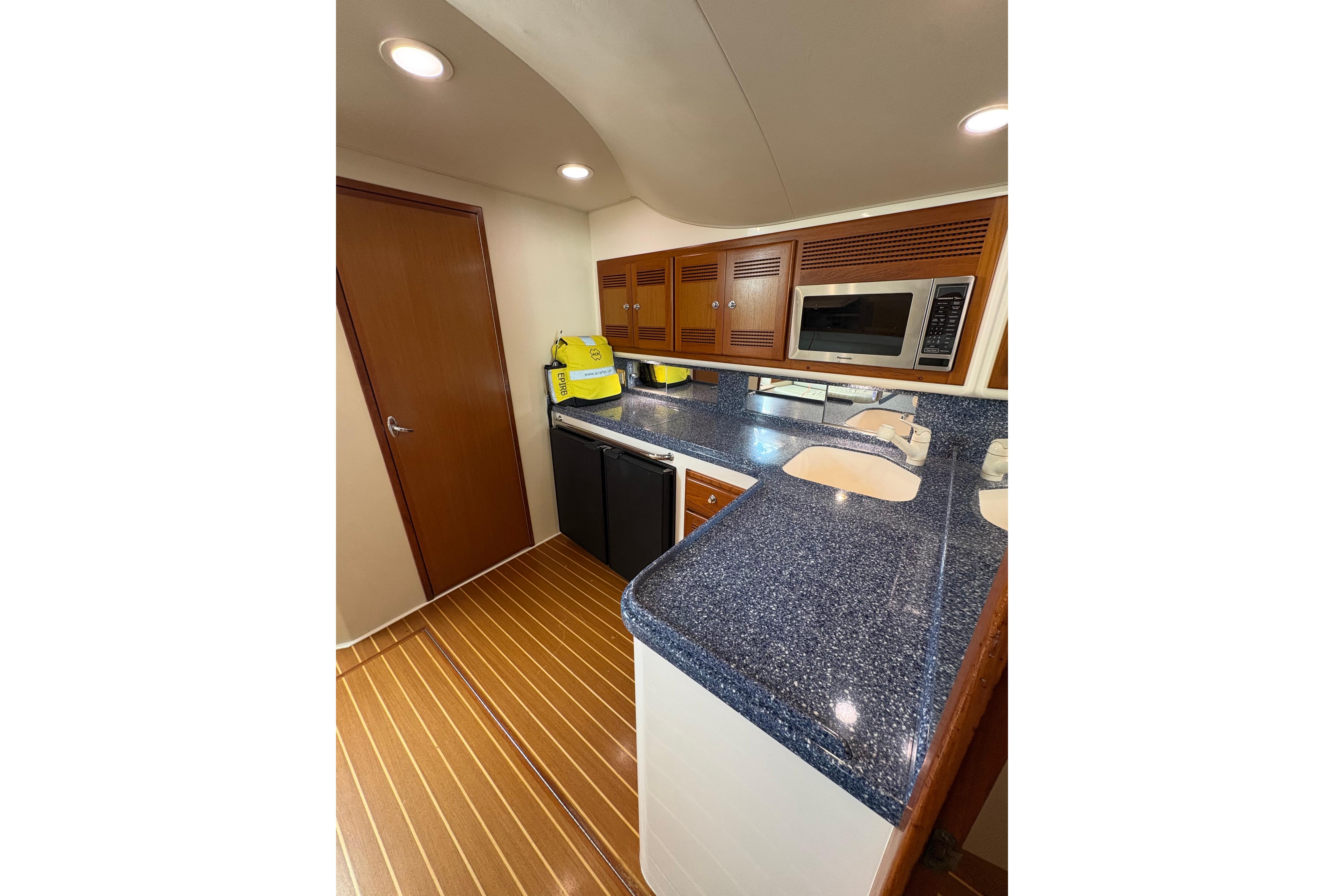 2004 Cabo 40 Hardtop Express yacht kitchen with blue countertops and wooden cabinetry.