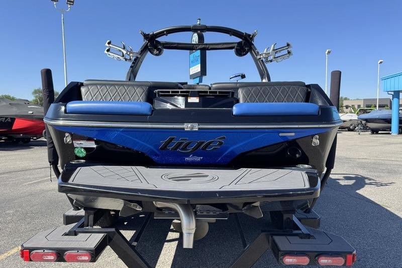 2022 Tigé Z3 boat rear view with blue accents and trailer in a parking lot.