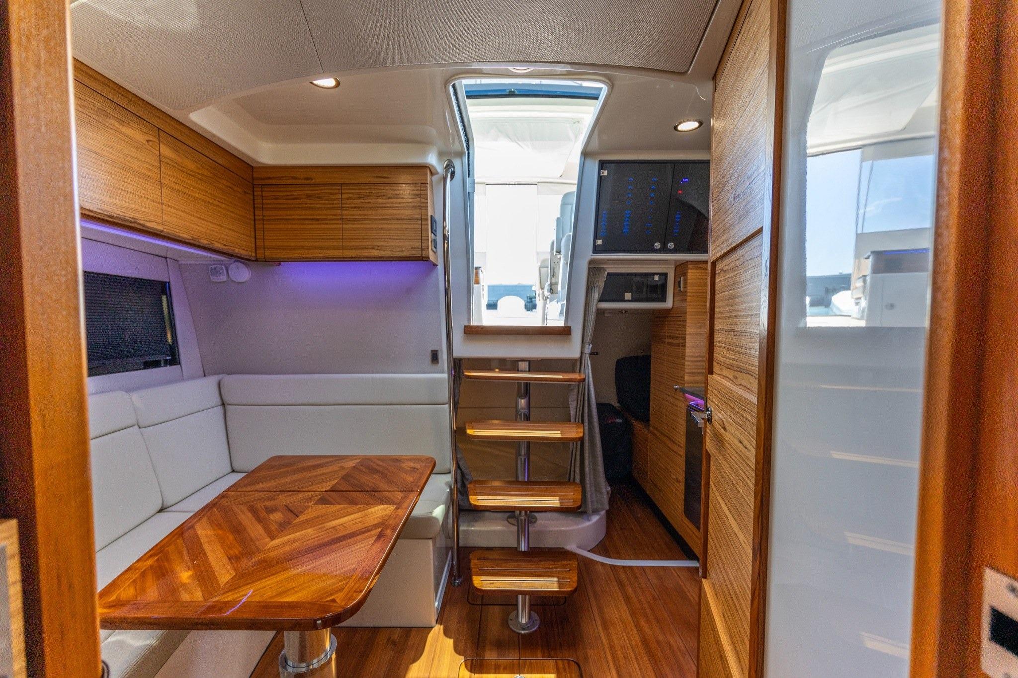 Interior of 2023 Boston Whaler 405 Conquest, featuring wooden accents and modern seating area.