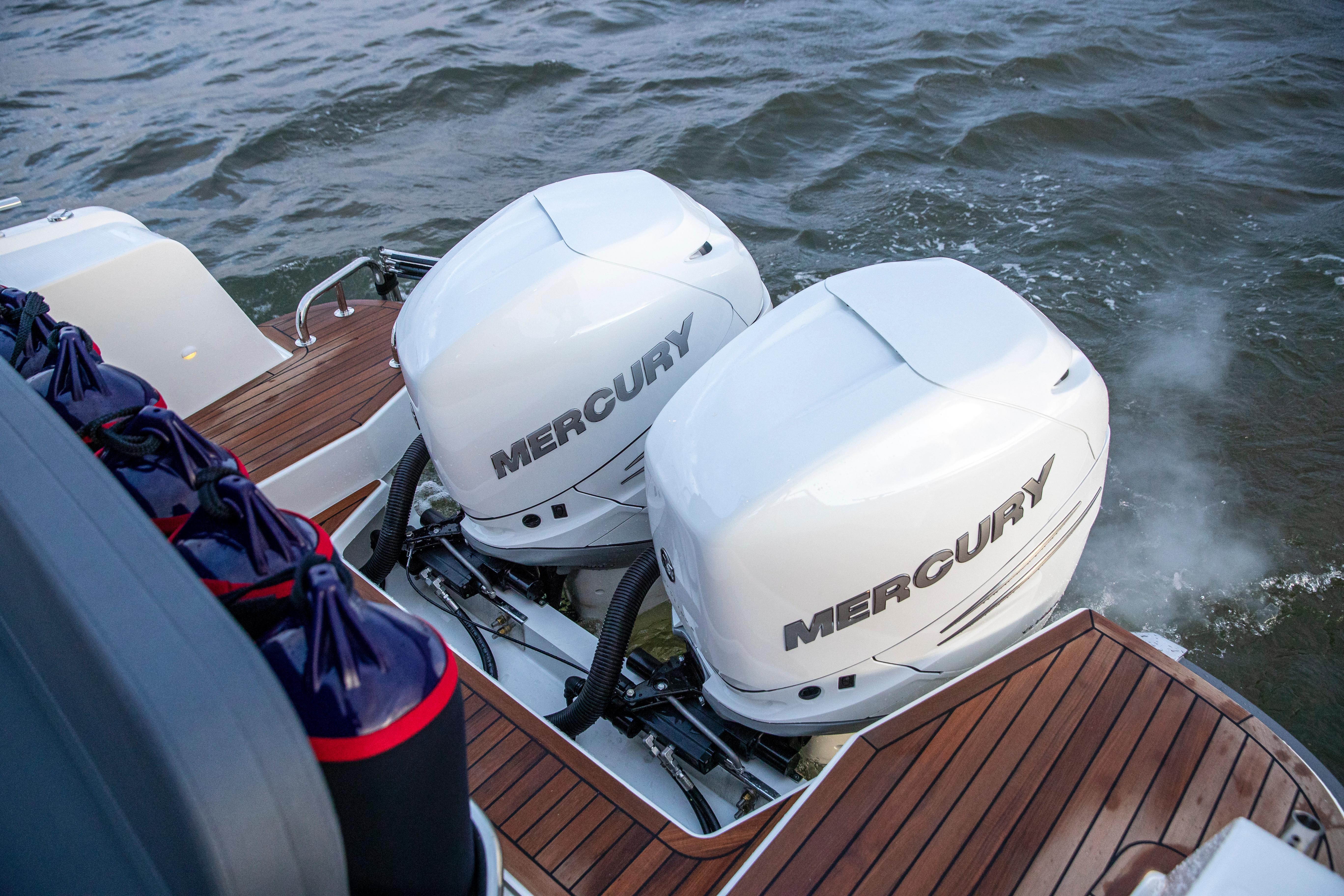 Twin Mercury outboard engines on a 2025 Nimbus C11 boat, cruising on water.