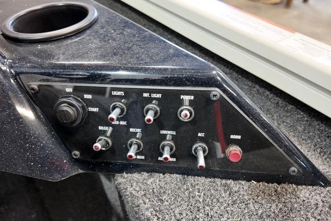 Control panel of 2024 Lowe Stinger 188 boat with switches and cup holder.