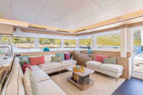 Luxurious interior of 2025 Lagoon 60 yacht with modern seating and large windows.