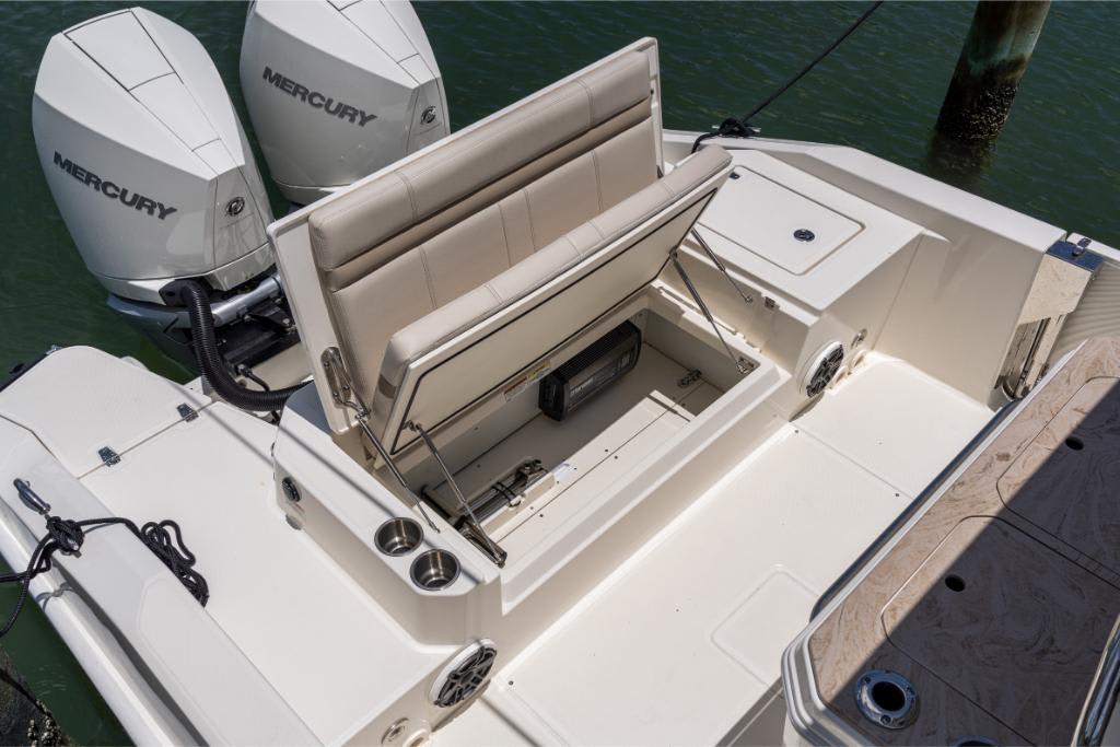 2024 Boston Whaler 280 Dauntless boat with open storage compartment and twin Mercury engines.