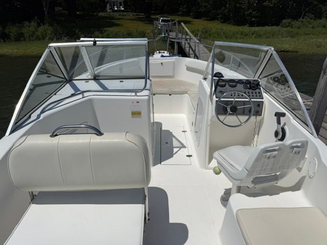 The image shows a 1999 Aquasport 215 DC boat with white interior and helm station.