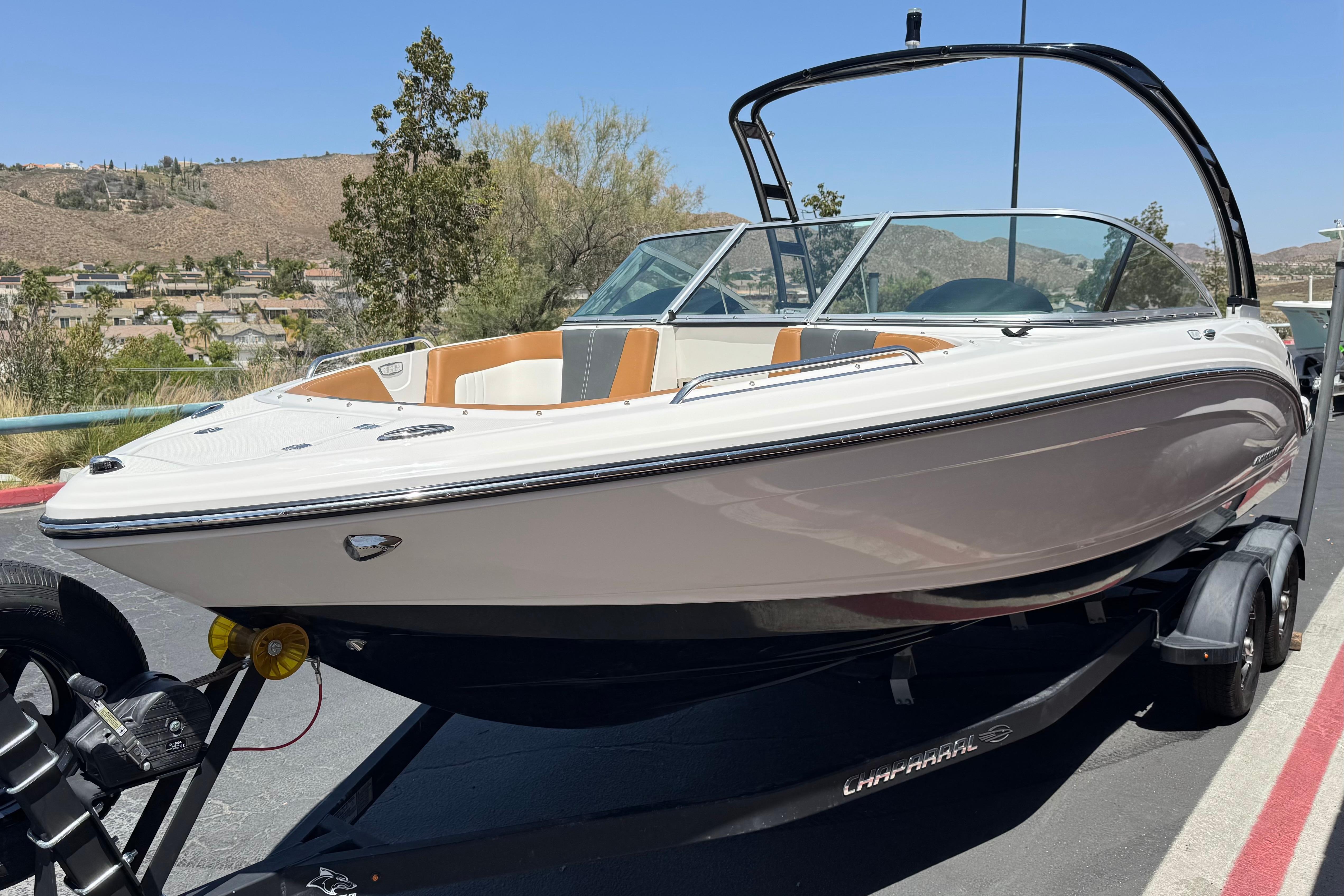 2023 Chaparral 23 SSi boat on trailer, parked outdoors with scenic background.