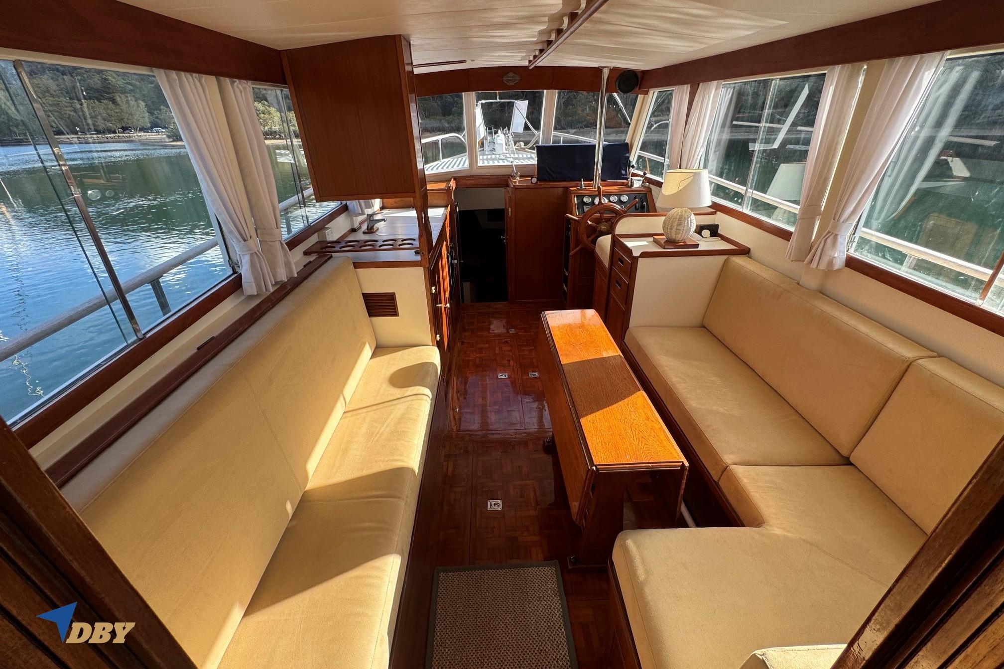 Interior of a 1980 Grand Banks 32 Sedan yacht with beige seating and wooden accents.
