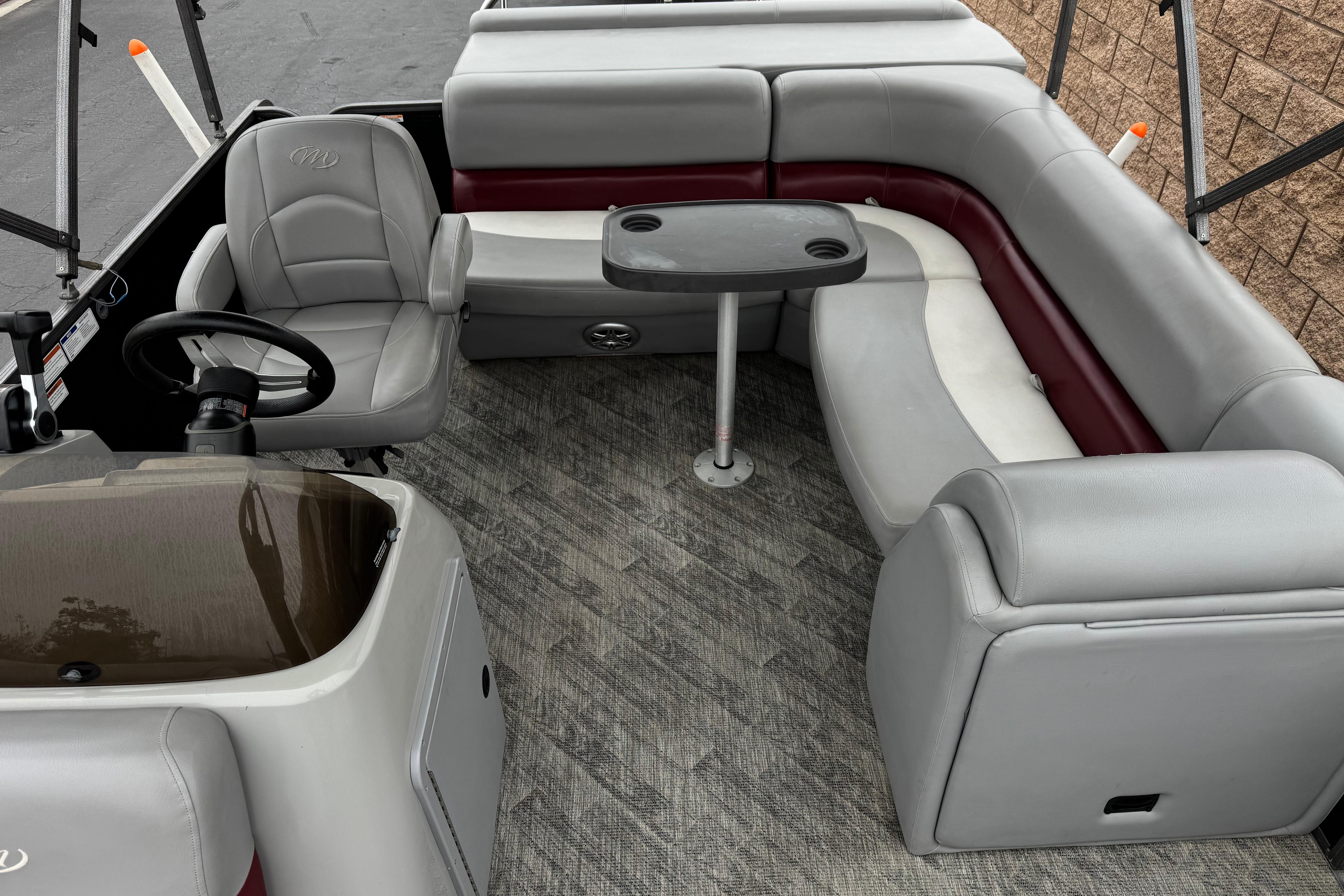 Interior of 2020 Manitou 18 Aurora LE pontoon boat with seating and steering area.