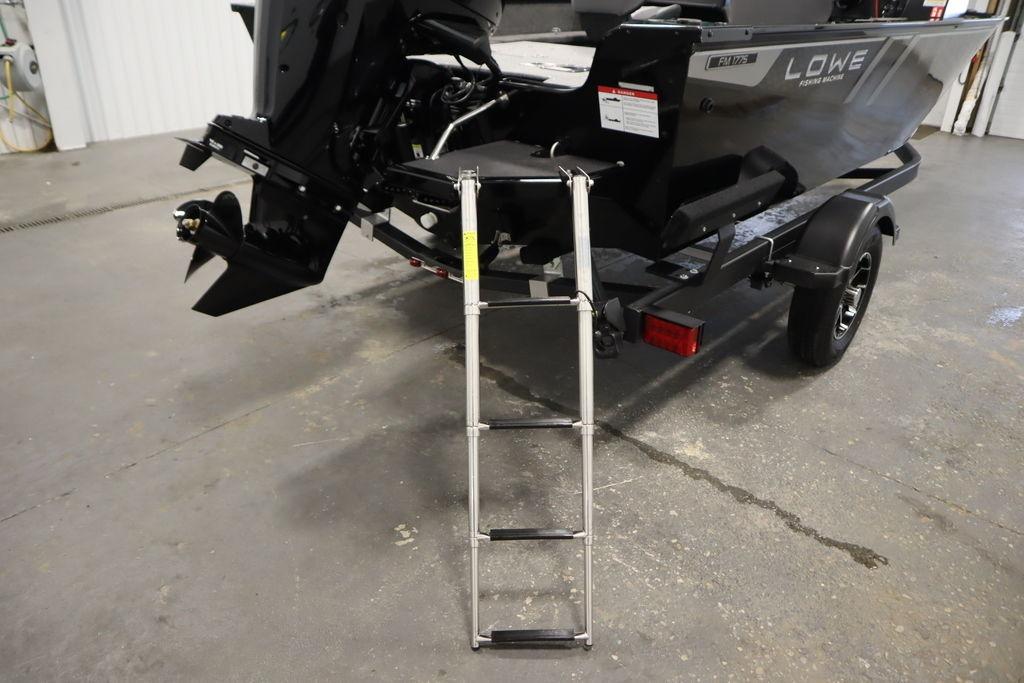 2026 Lowe Fishing Machine 175 boat with ladder and trailer in a garage.