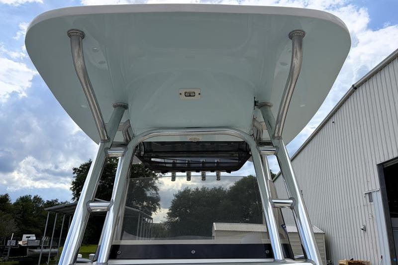 2024 Key West 239 FS boat with T-top and stainless steel supports, under a cloudy sky.