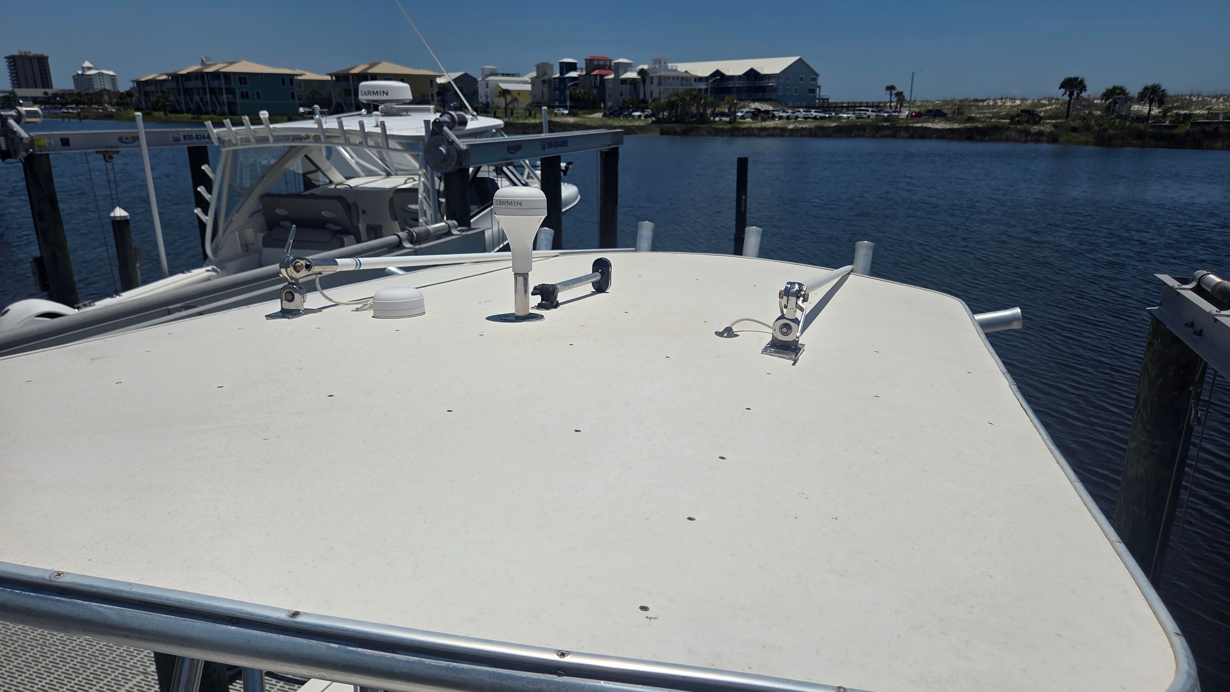 A boat docked with a view of calm water and buildings in the background.
