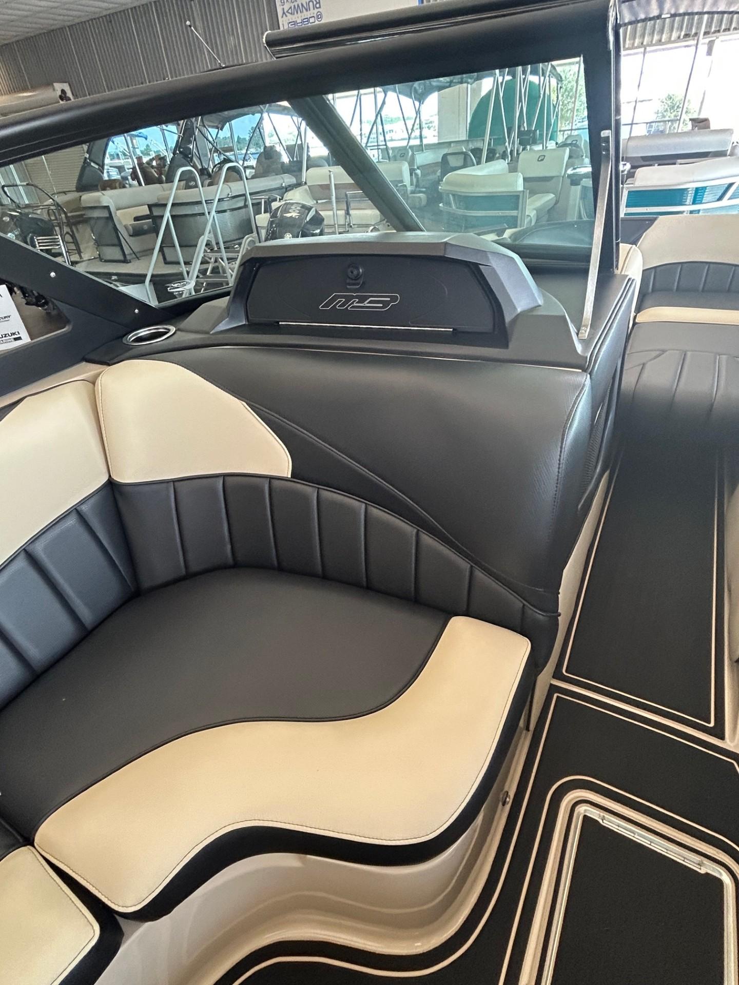 2024 MB F22 Tomcat boat interior with black and beige seating in showroom.