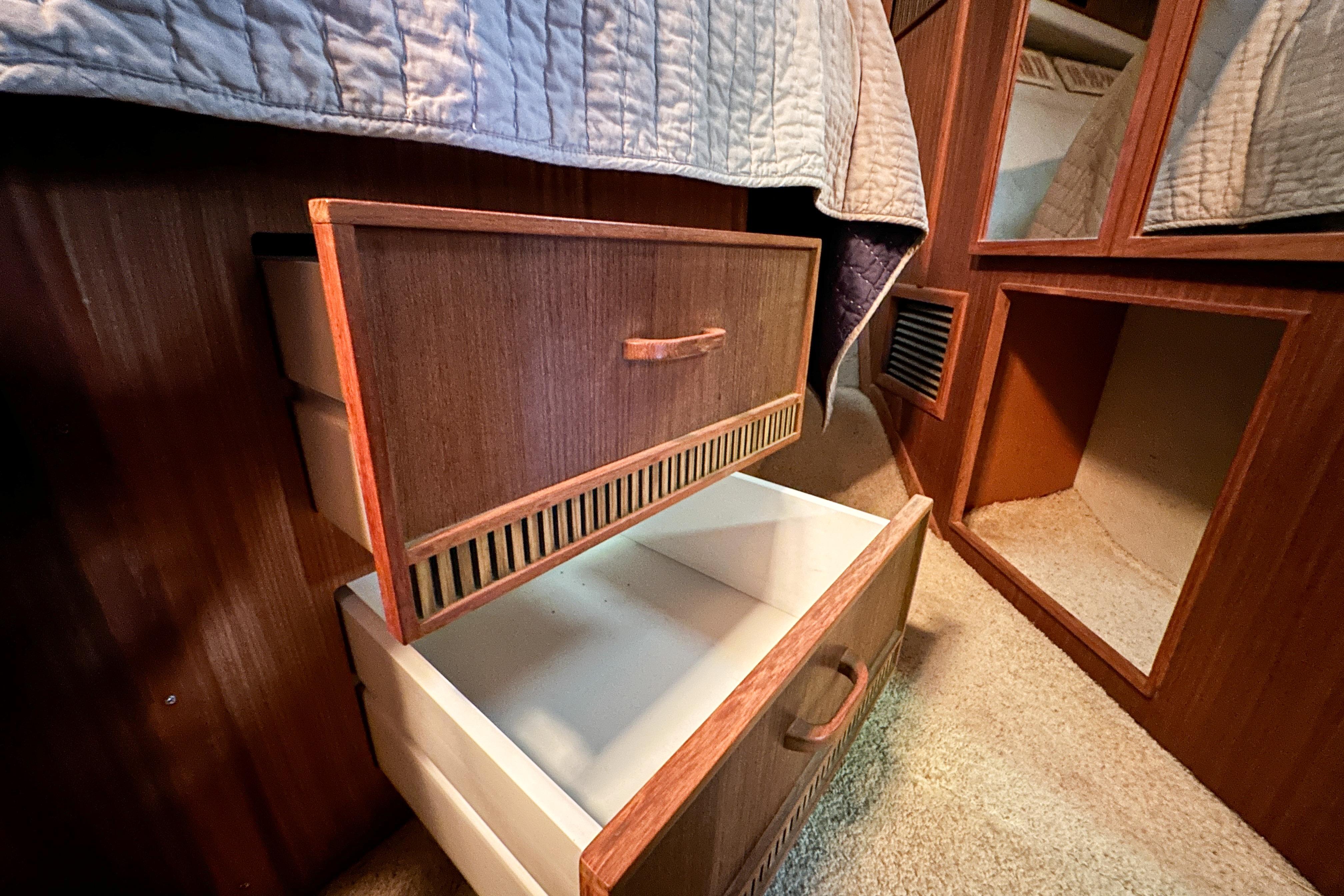 Open wooden drawers inside a 1986 Sea Ray 390 Express Cruiser cabin.