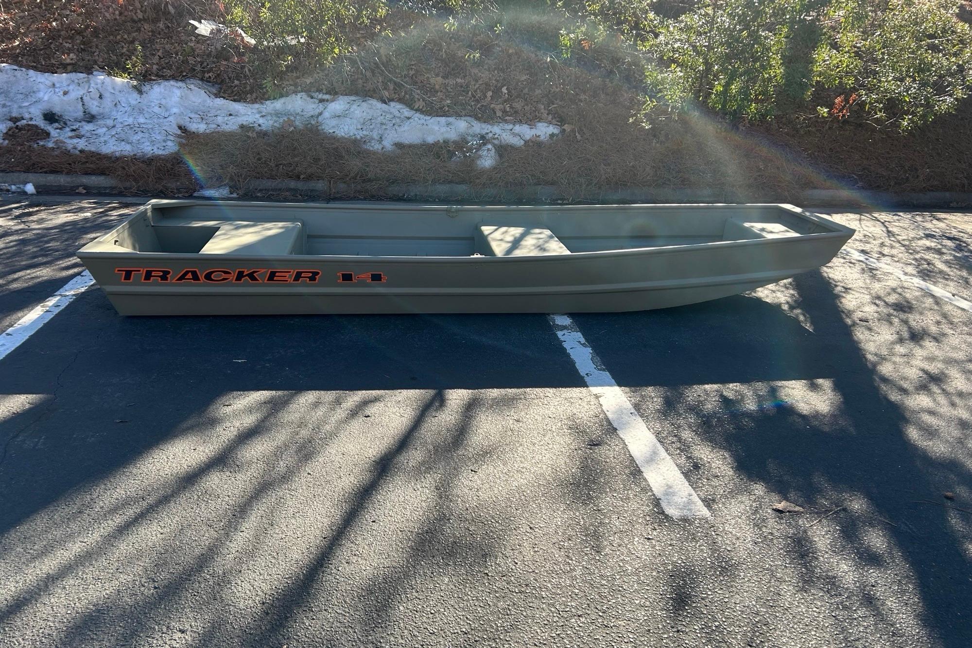 2026 Tracker Grizzly 14 Jon boat parked on asphalt under sunlight.