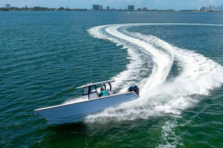 2027 Reef Runner 340 boat making a sharp turn on open water.