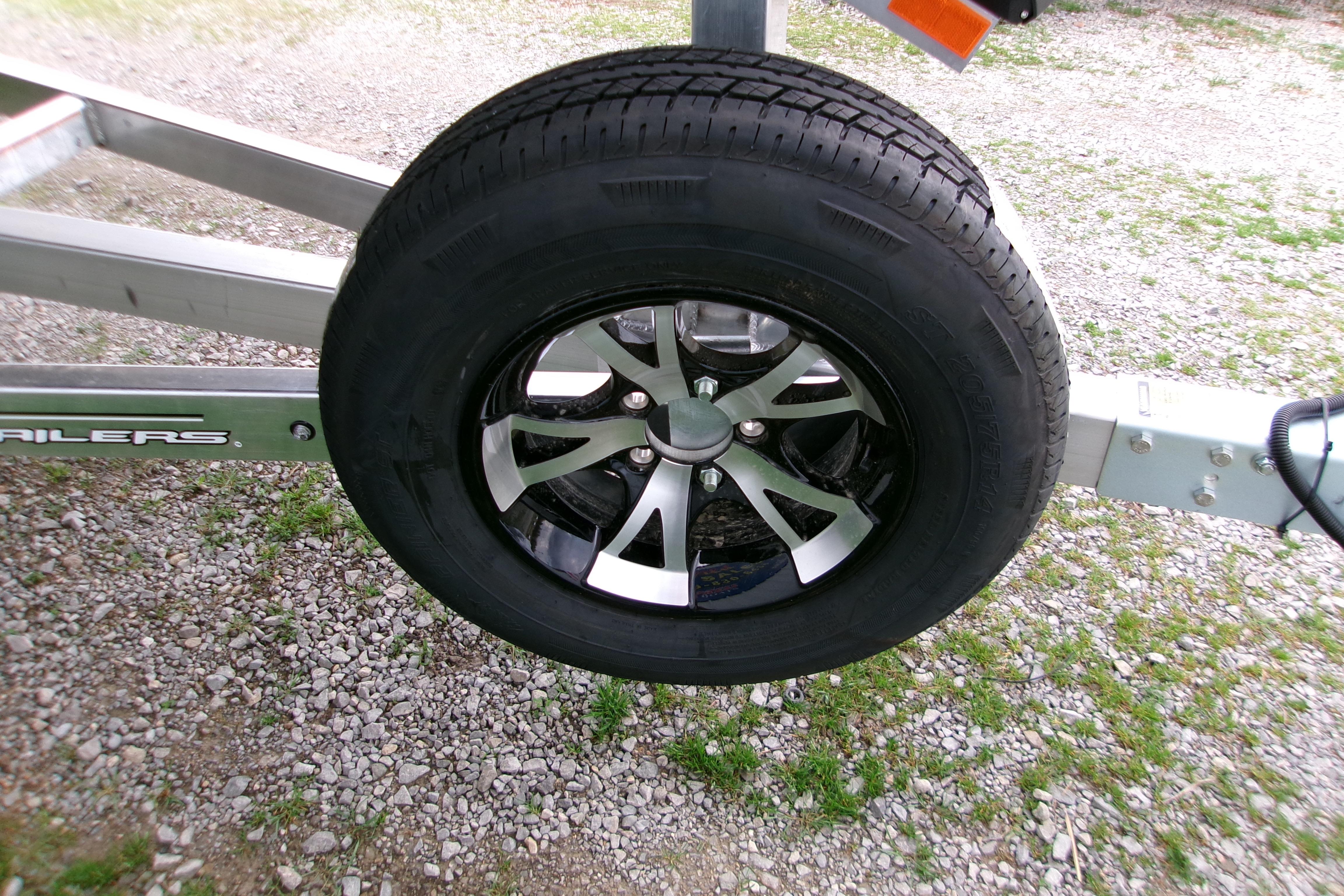 2026 Xpress H22B Bay trailer wheel on gravel surface.