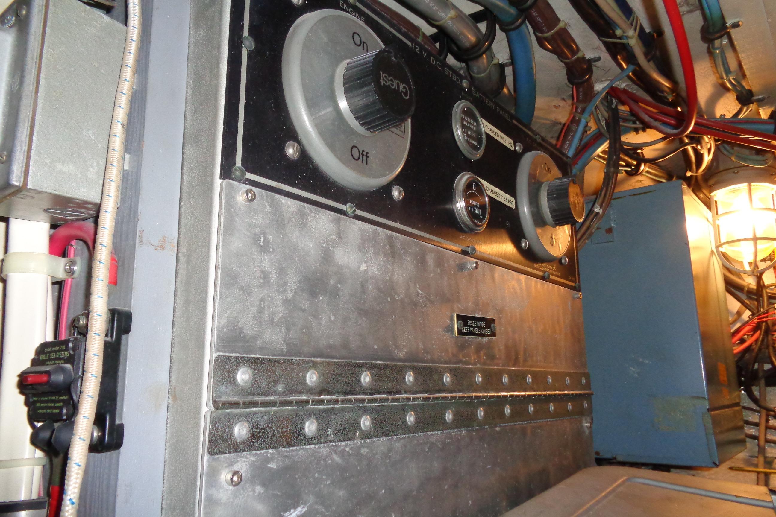 Engine room of 1981 Hatteras 48 Cockpit Motor Yacht with control panel and wiring.