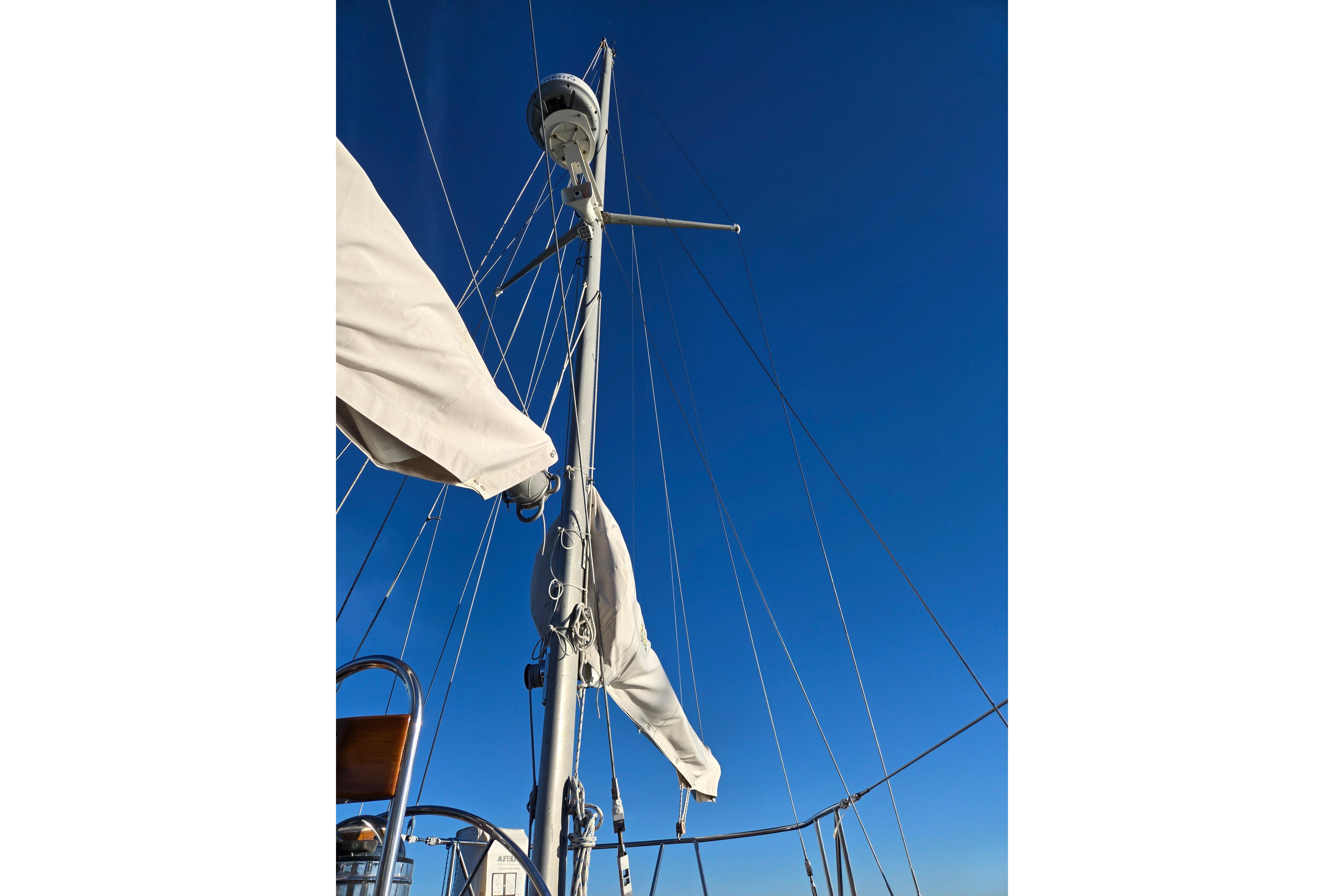 Mast and rigging of 1970 Hinckley Bermuda 40 sailboat against clear blue sky.