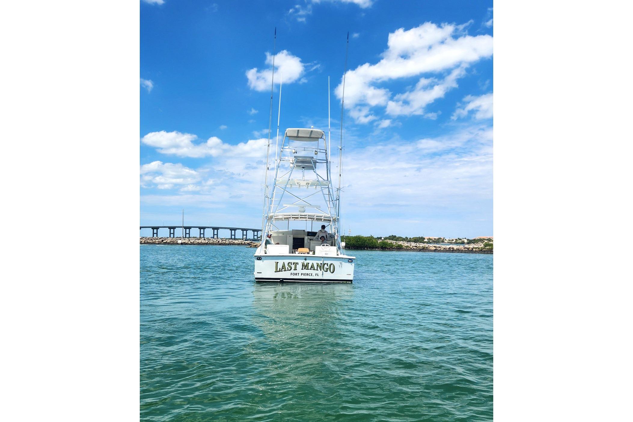 1987 Young Brothers Custom Sport Fish boat on water under blue sky.