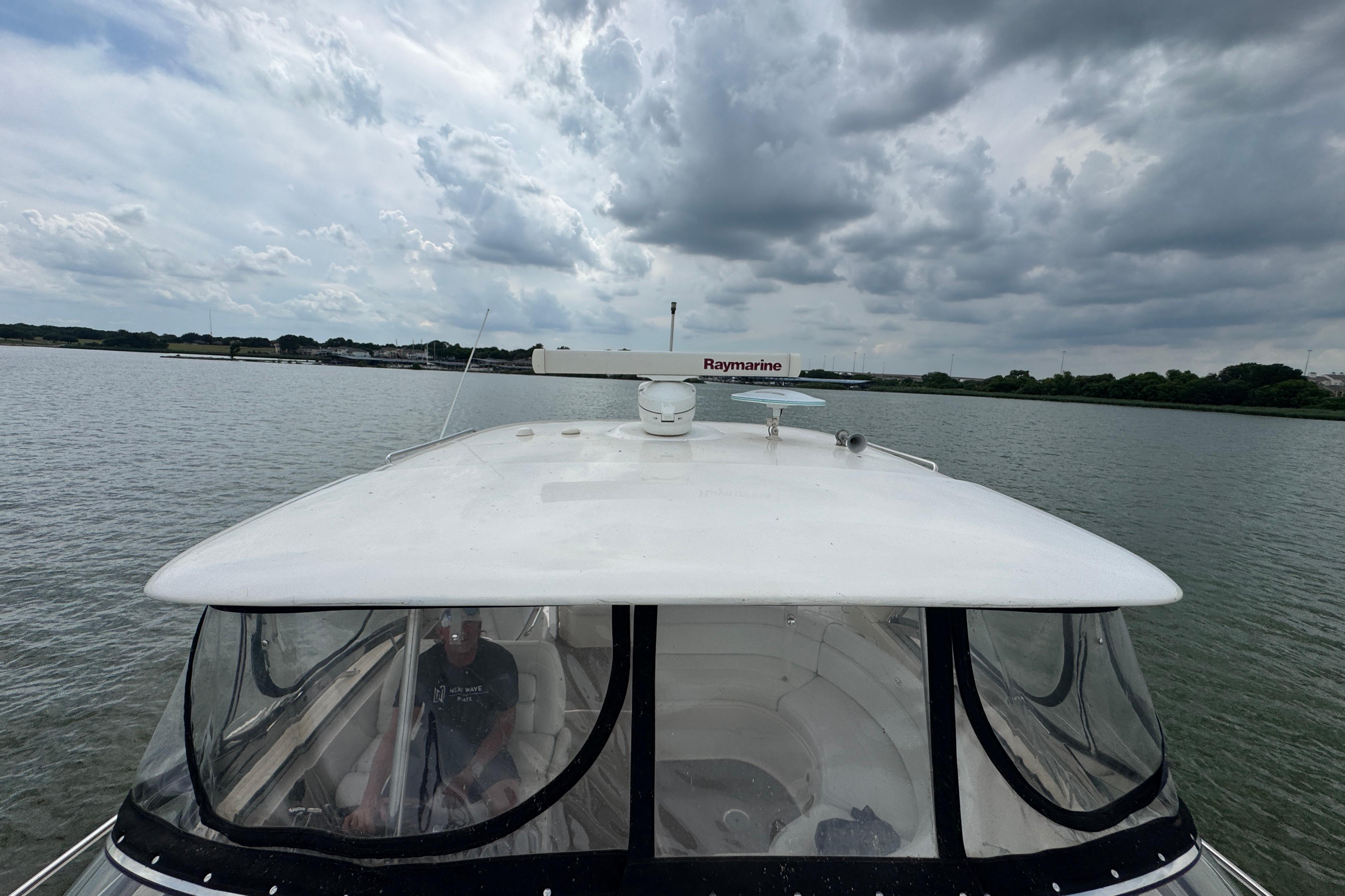 2005 Regal Commodore 4260 yacht navigating under cloudy skies on a calm waterway.