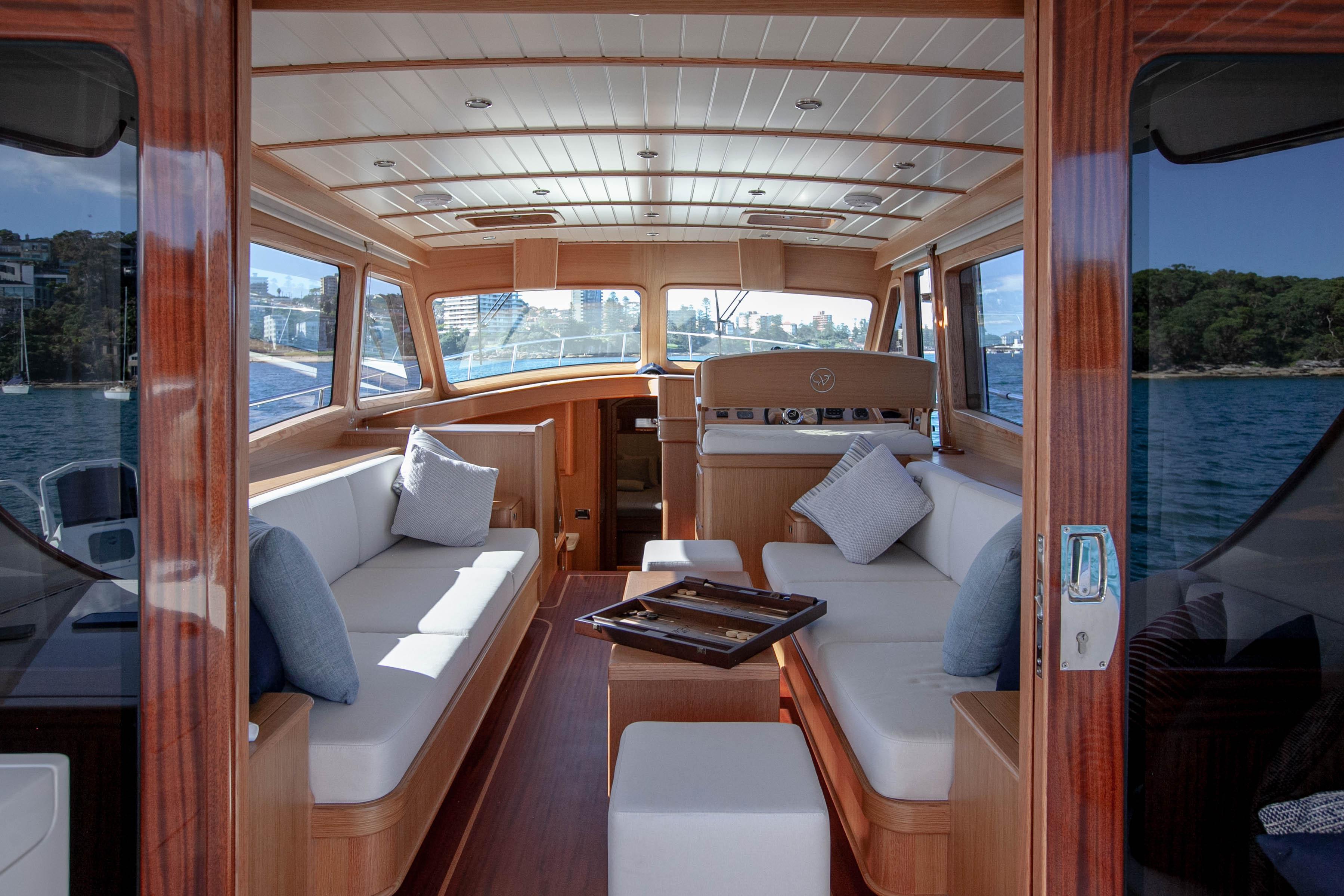 Luxurious interior of 2023 Vicem 55 yacht with elegant wood finish and plush seating.