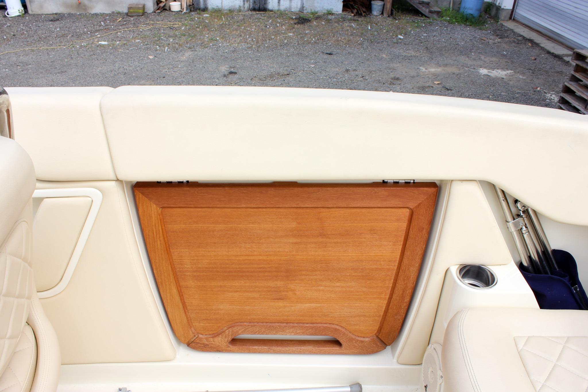 2017 Chris-Craft Capri 27 interior with wooden panel and beige upholstery.