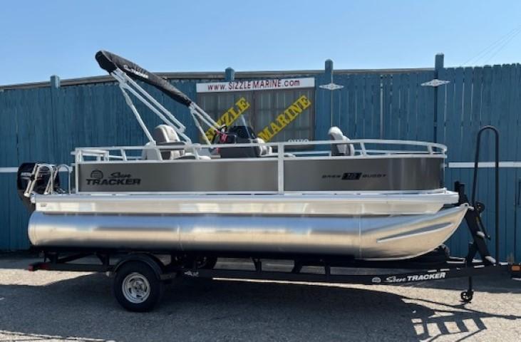 2026 Sun Tracker Bass Buggy 18 DLX pontoon boat on trailer, parked outdoors.