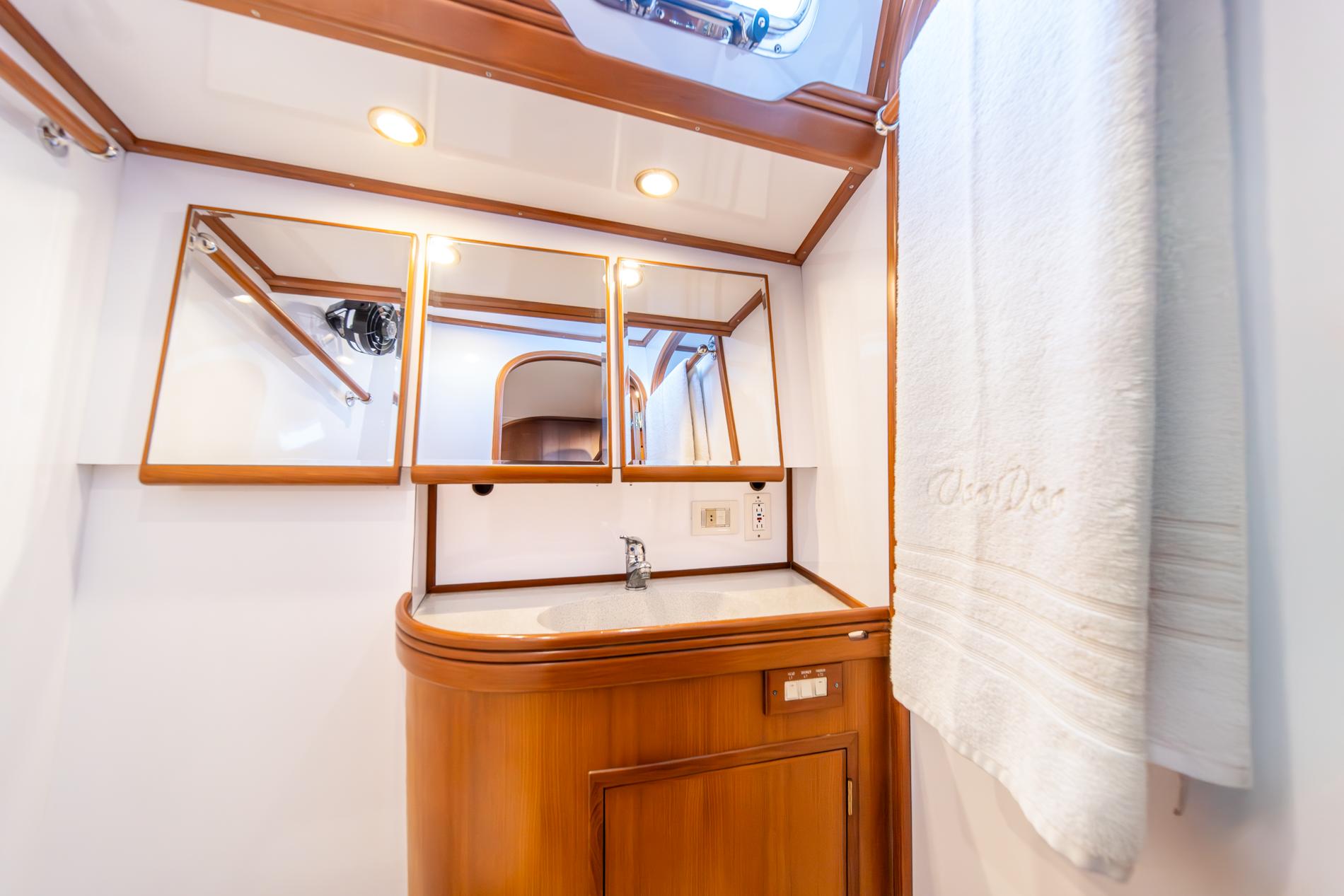Luxurious bathroom interior of 2010 Hylas 70 yacht with wooden cabinetry and mirrors.