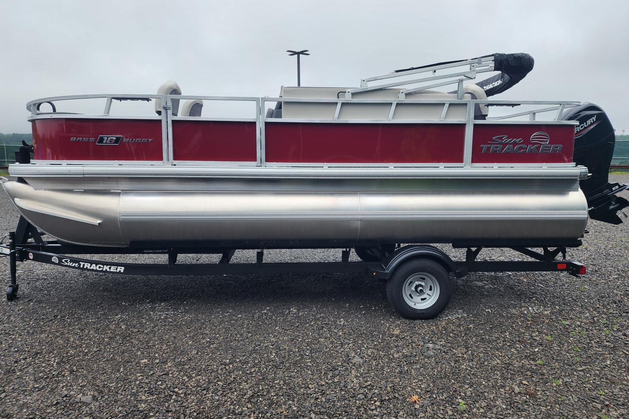 2026 Sun Tracker Bass Buggy 18 DLX pontoon boat on trailer, side view.