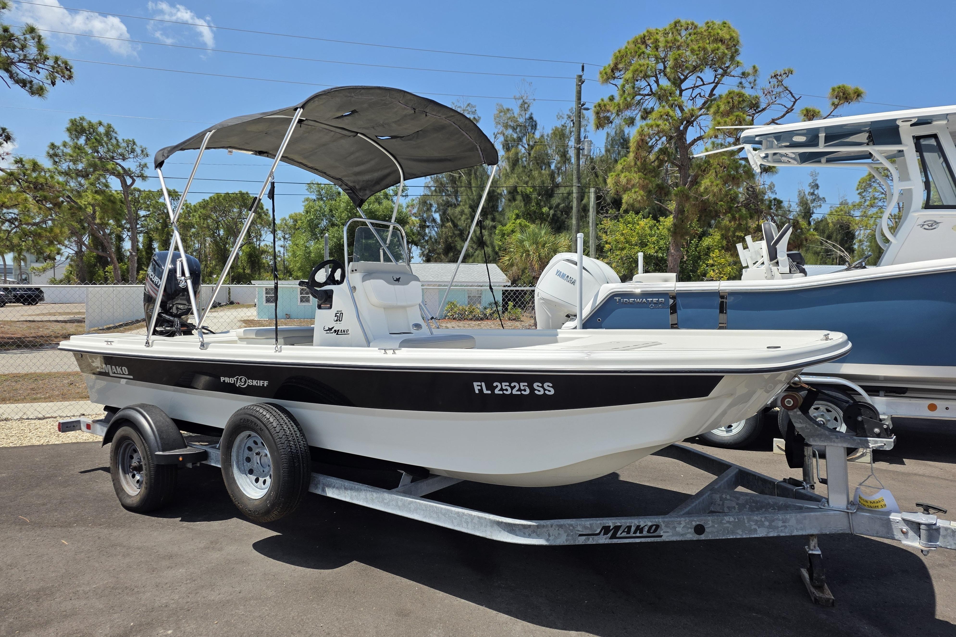 2018 Mako Pro Skiff 19 CC boat on trailer, parked outdoors under clear sky.